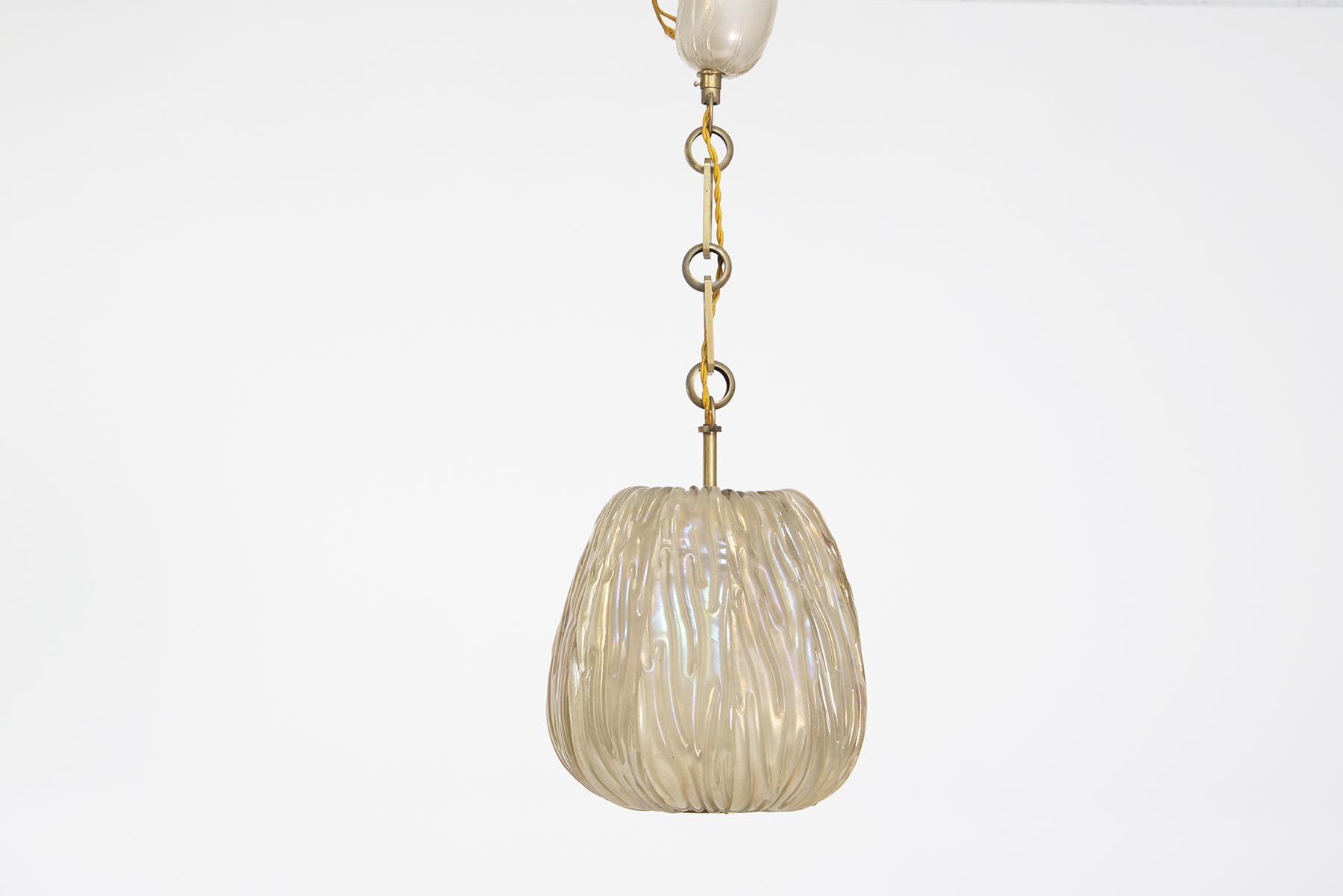 Magnificent Venini pendant in irridescent glass from the 1940s.
The pendant is made of 9 segments in irradiated glass, inside each segment there are beautiful grooves where the light of the glass reflects to create beautiful play of light. Each