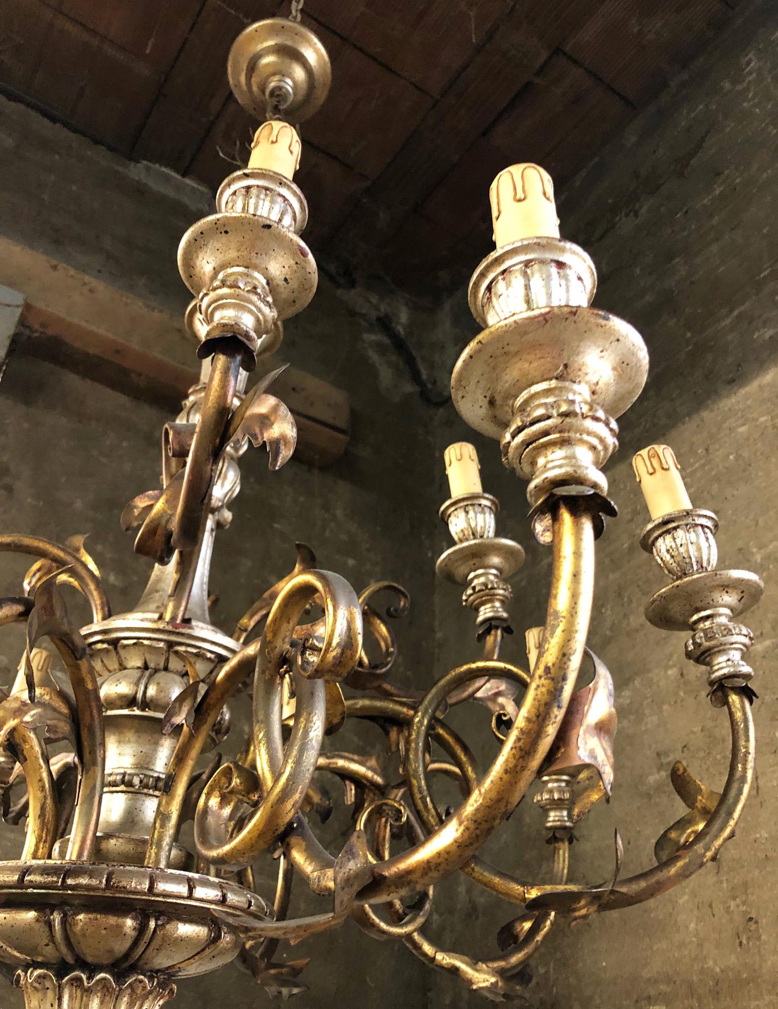Italian chandelier with 12 lights in wood and metal, very elegant.
Original from 1930. 
Very special patinated color.
Comes from an old city villa in the Florence area of Tuscany.
As shown in the photographs and videos, there are some small