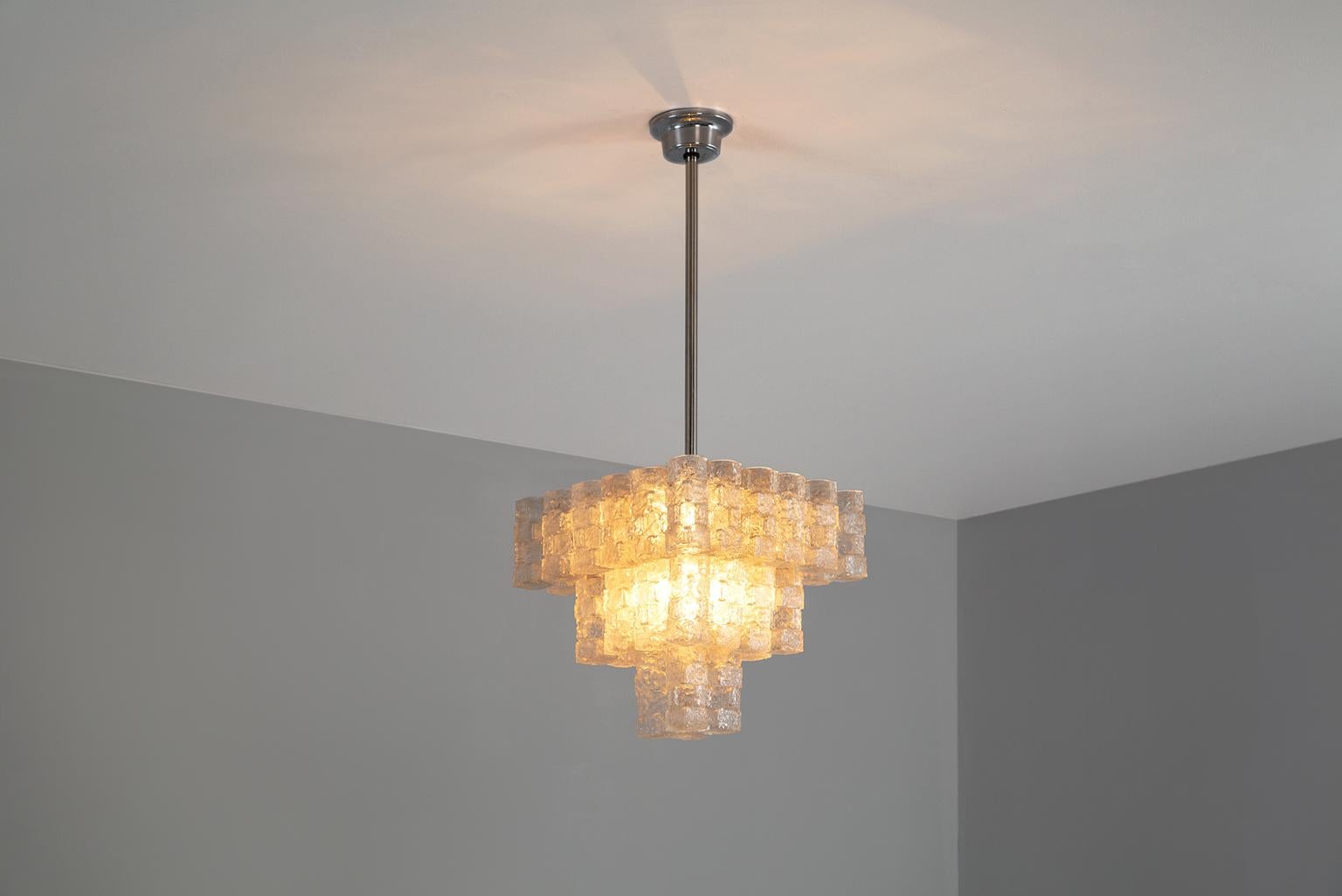 Stunning modernistic chandelier, framed by 36 frosted glass sculptures.
The glass sculptured are hanged on three different levels, covering the lamp sockets. This creates a nice and stunning light partition.

All images also available in high