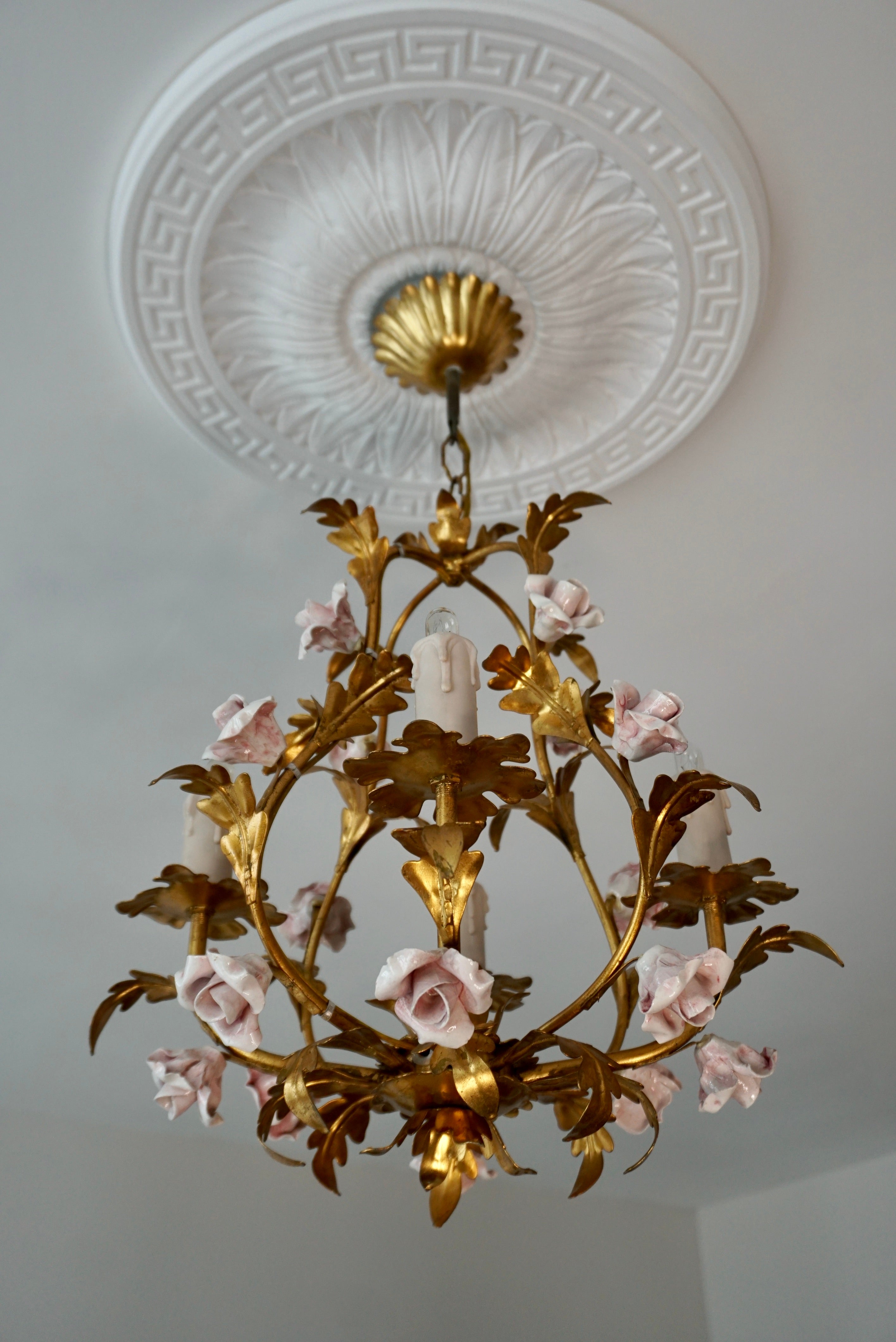 Italian Hollywood Regency four light chandelier in brass with yellow porcelain rose flowers. 
We have 4 pieces with pink flowers and 1 with yellow flowers.

Diameter 15