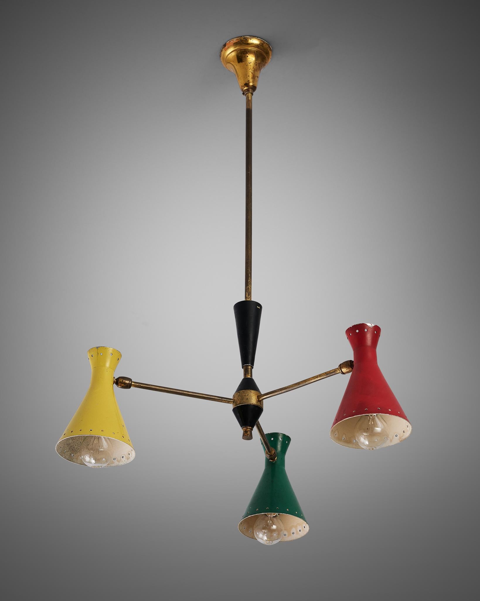 Lampadario, metallo, ottone, Italia, anni '50

Bellissimo lampadario italiano con paralumi colorati a forma di cono. Una struttura a treppiede in ottone sostiene i paralumi verdi, rossi e gialli con perforazioni lungo i lati che possono essere