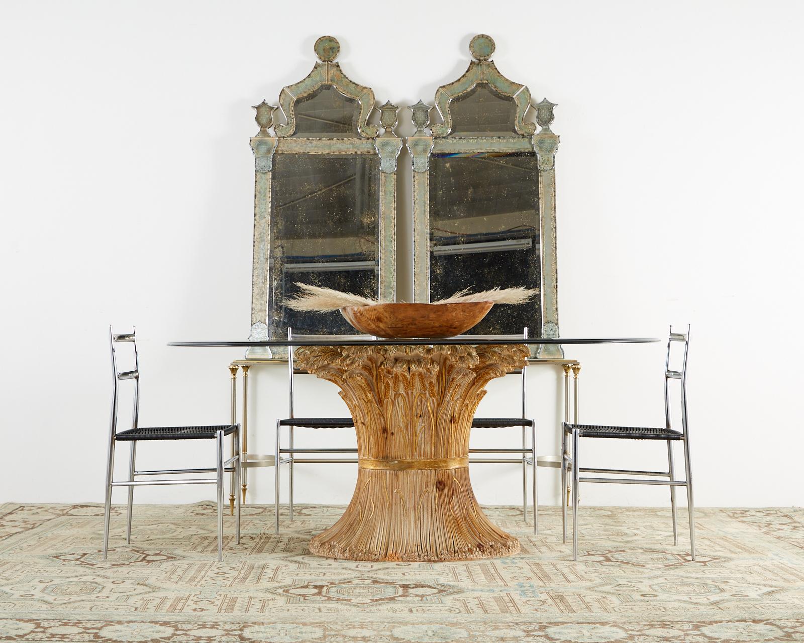 Extraordinary Italian carved dining table featuring a hand-crafted, parcel gilt base depicting a wheat sheaf. Artisan made in Florence, Italy by Chelini model number art 176. Incredible detail with a beautifully aged patina. Topped by a thick oval