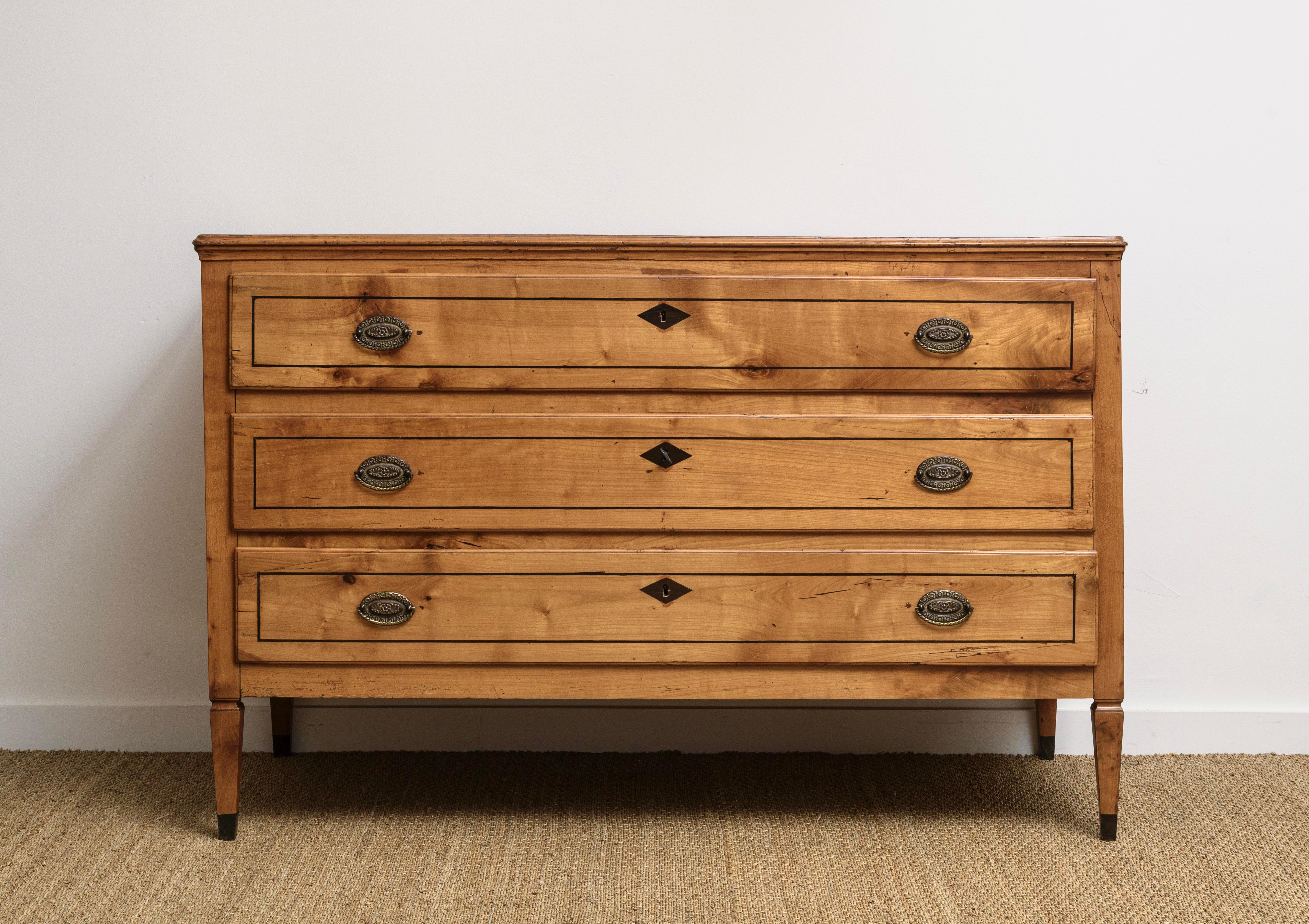 An Italian Cherry Neoclacial-style Commode, from  Bologna, with three long drawers, the drawers and posts decorated with Pearwood designs, with matching design on flat panel sides on tapering legs,   Large chest great for storage.   Ca 1850  With