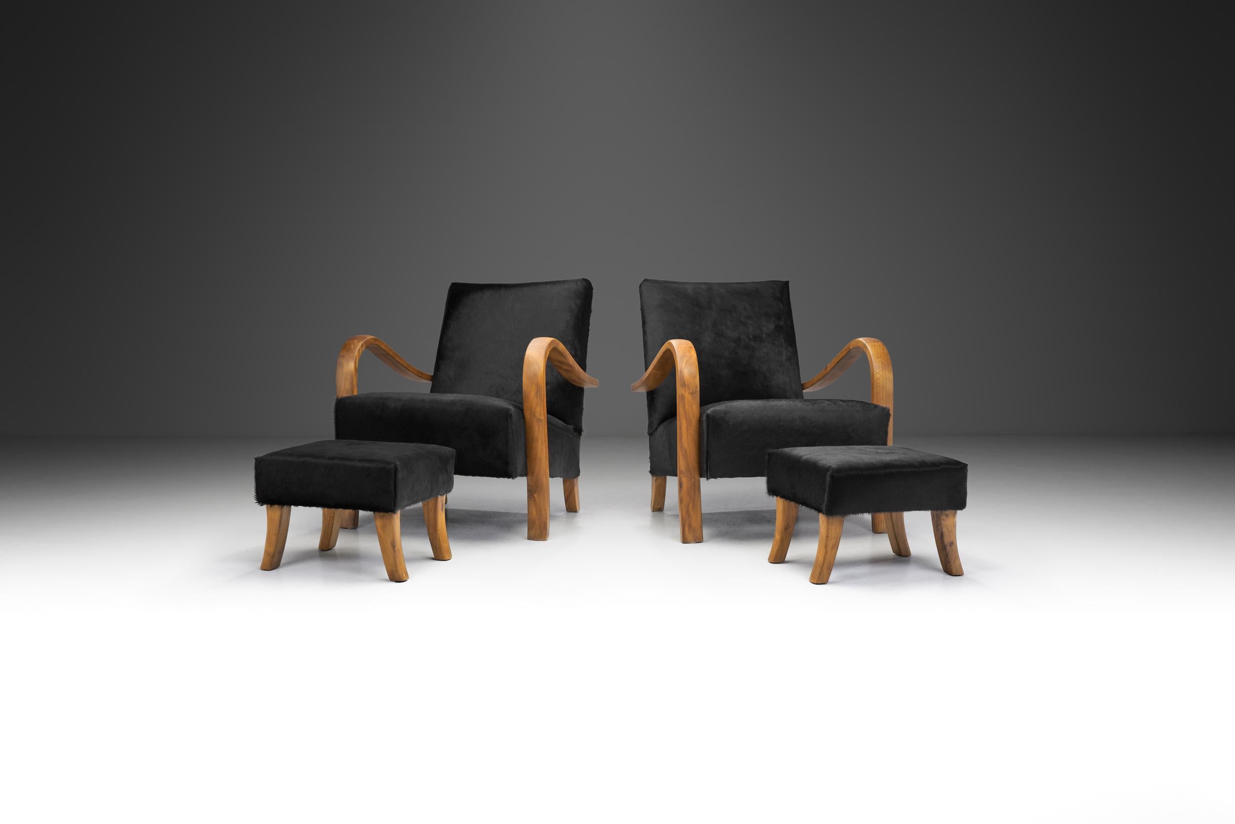 Crafted in Italy during the 1950s, this pair of Italian cherry wood lounge chairs with foot stools embodies the essence of mid-century modern design, seamlessly blending organic elegance with functional comfort. These chairs stand as timeless