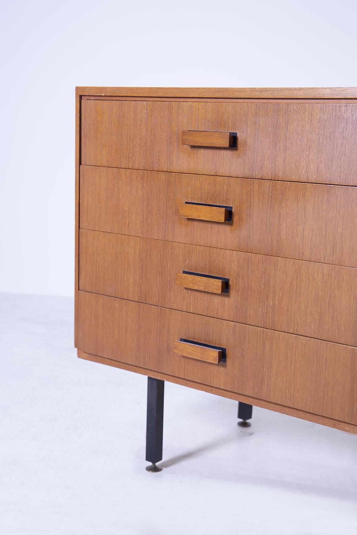 Vintage Italian chest of drawers from the 1950s. The chest of drawers is made of walnut wood with 6 drawers that can be pulled out via a geometric wooden handle. Its feet made of iron in a rectangular shape create and make the chest of drawers