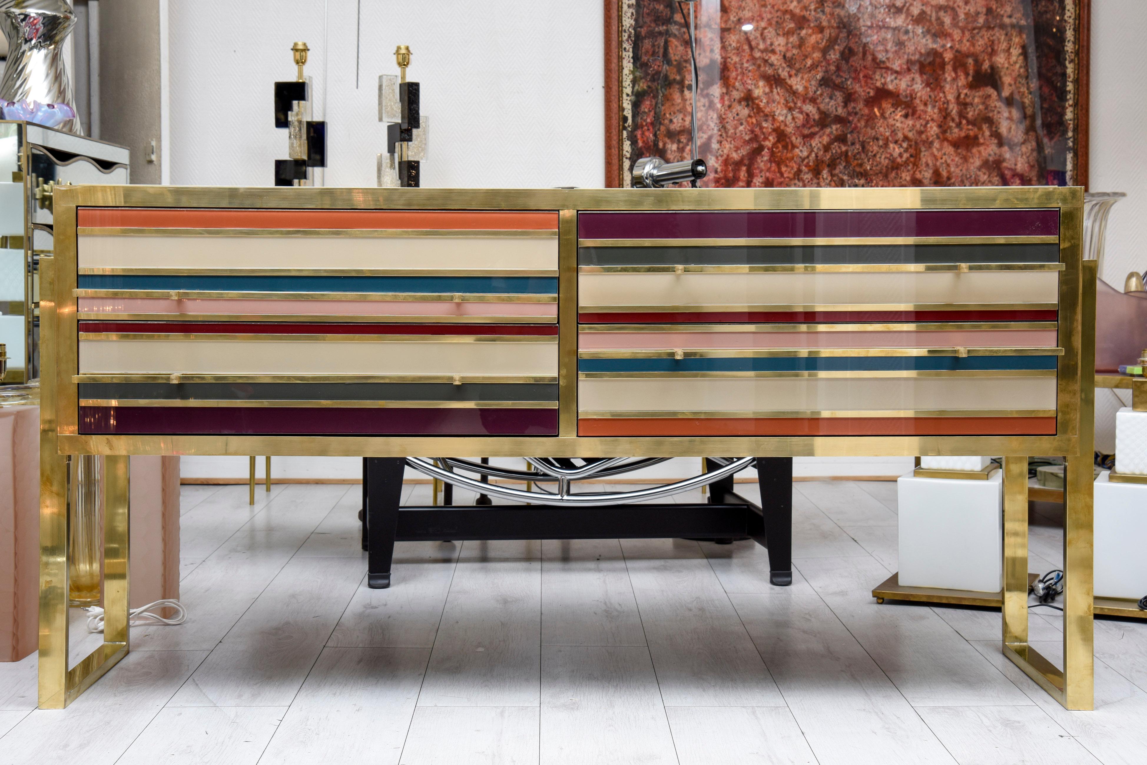 Italian chest of drawers in tinted glass and brass with four drawers.