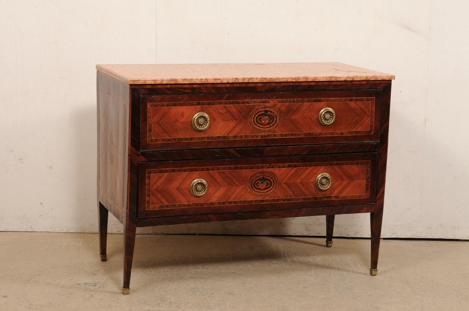 An Italian raised two-drawer chest, with its original marble top, from the late 18th century. This antique chest from Italy retains its original marble top, which rests atop a case beautifully adorn in veneered inlays and banding, which houses two
