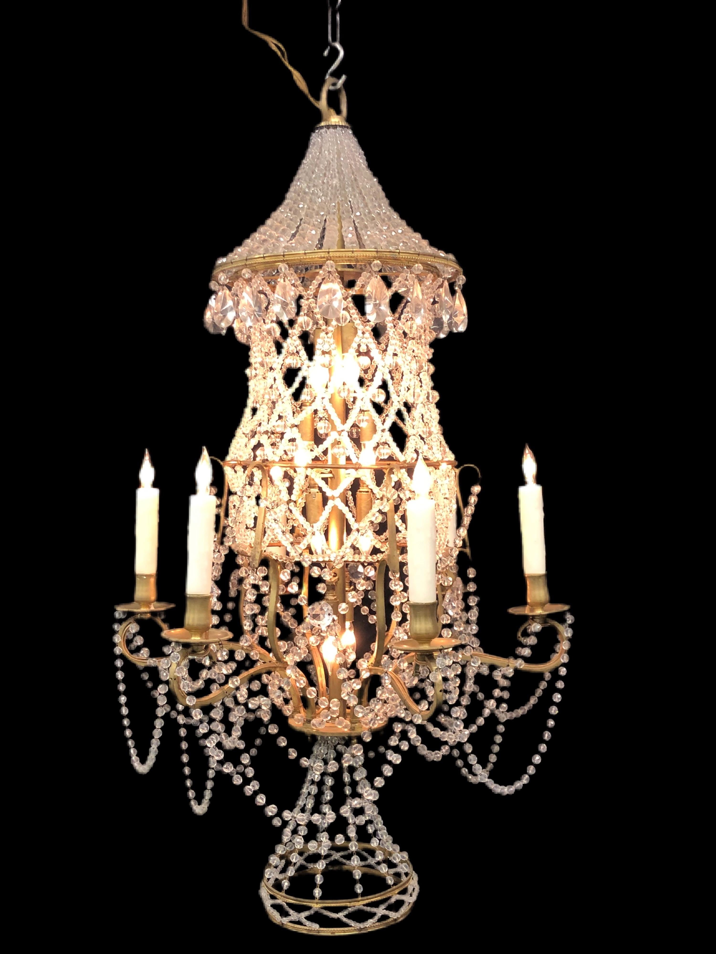 A sophisticated Italian crystal Chinoiserie pagoda chandelier in the Regency style is from the early 20th century. The bronze Pagoda frame is draped in crystal beaded chain in a diamond pattern with the top diamond patterns having crystal spheres