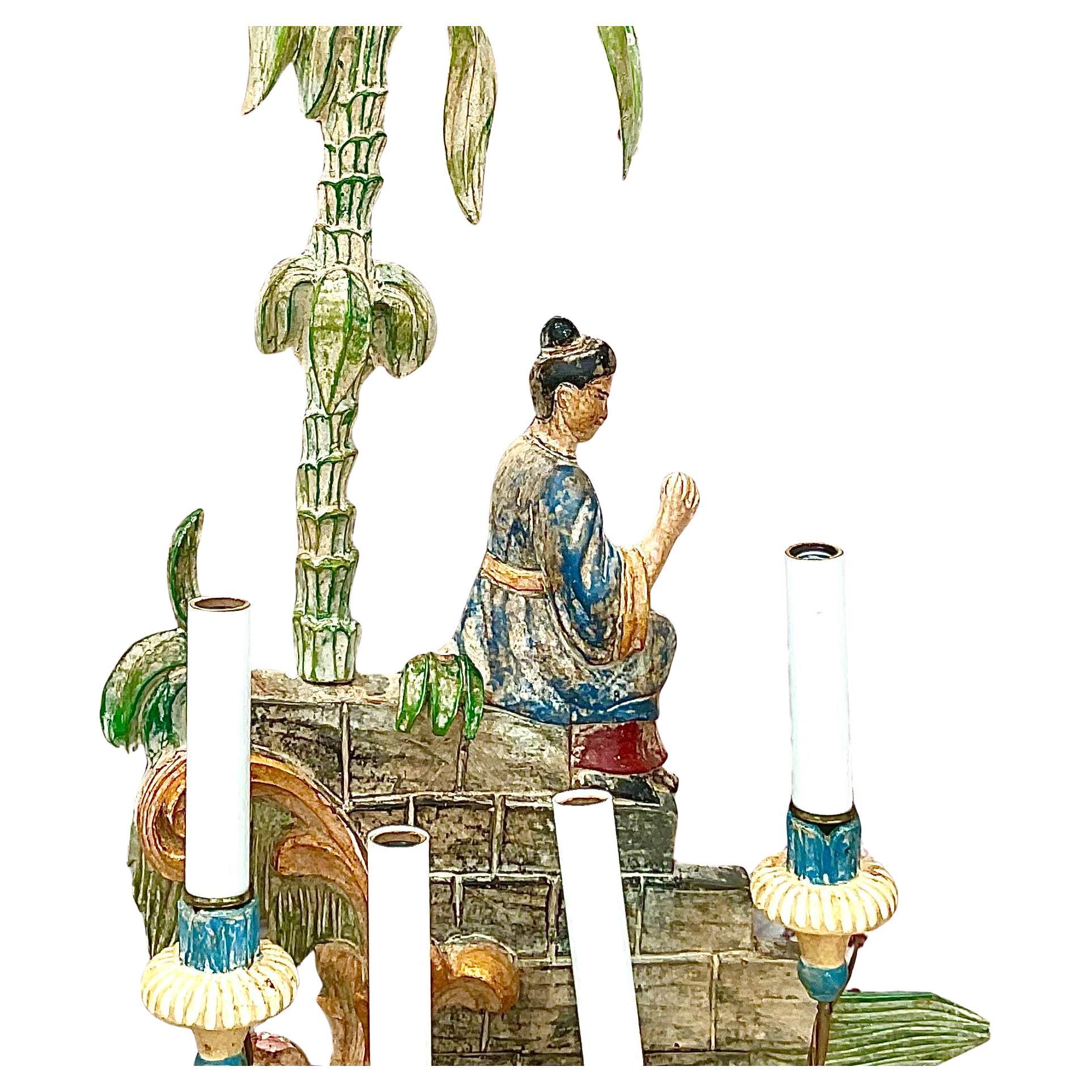 Bellissima coppia di applique Chinoiserie. Ogni applique presenta quattro luci su alti portacandele in metallo curvato. Le luci sono cablate. Gli sfondi a cineserie presentano figure asiatiche in abiti tradizionali, sedute su un muro vicino a delle