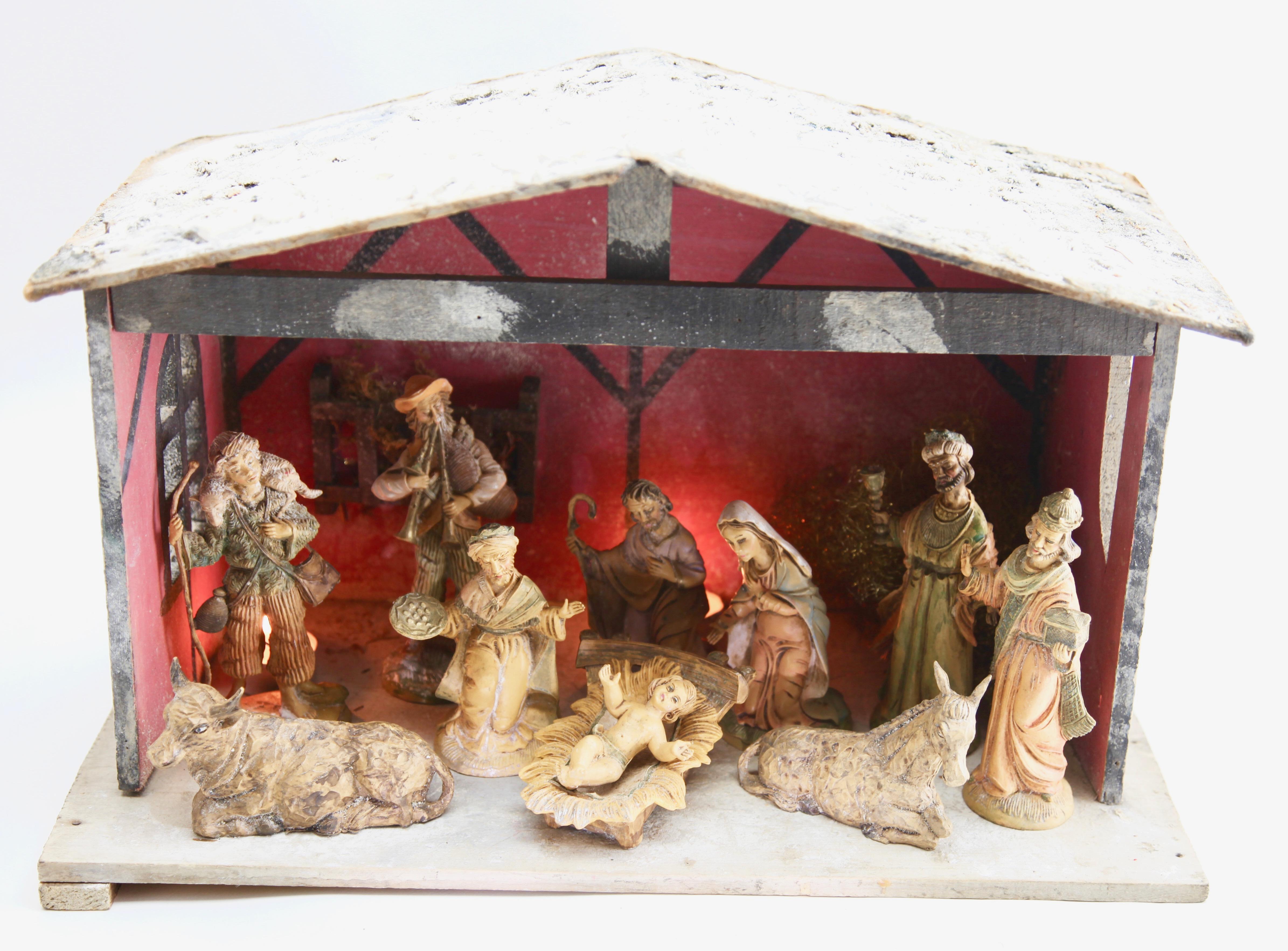 Christmas nativity scene of highly detailed hand painted figurines including Mary and Joseph, three kings, shepherds, Christ-figure in a manger with an ox and an ass. 10 pieces in total. As background, a handcrafted wooden stabile.
Charming