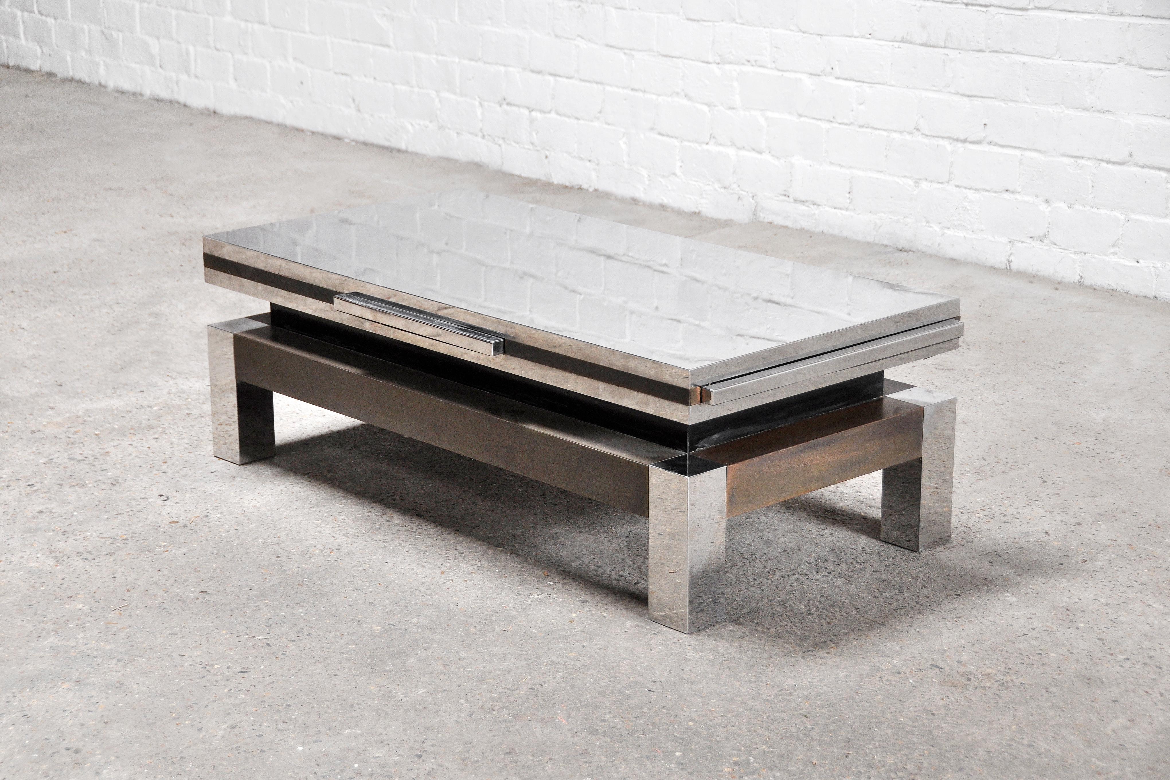 A unique and rarely seen extendable coffee table by Sando Petti, 1970's. Constructed out of chrome and brass, this table is a truly shiny conversation piece. Each side features a chrome pull out tablet that widens and lengthens the table by almost 2