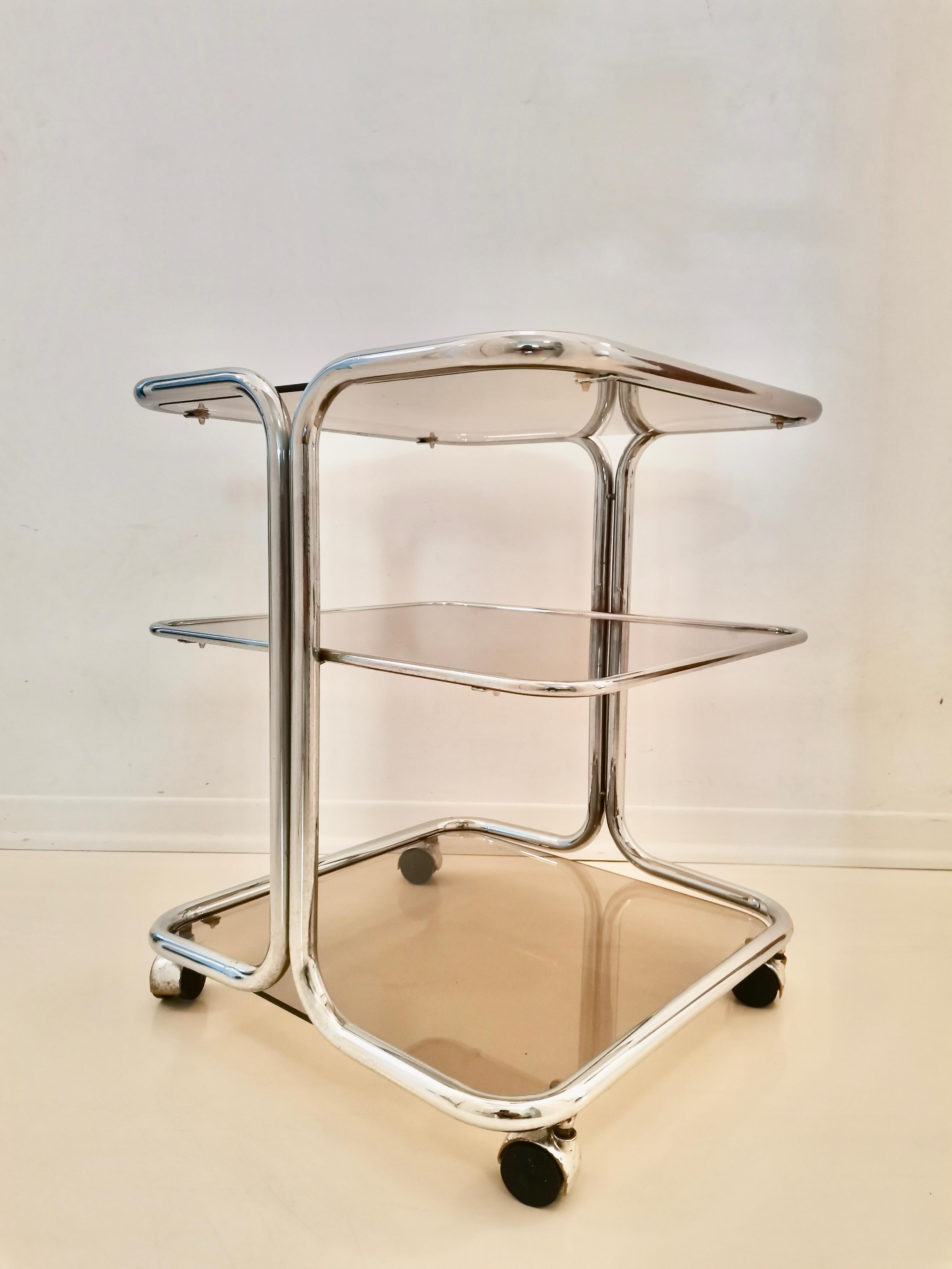Magnificent Italian chromed vintage bar cart. All original parts. The trolley has three shelves in smoked glass. Its modern yet classic design gives impression of luxury and style. Can be combined with all styles of furniture and interiors.

Period: