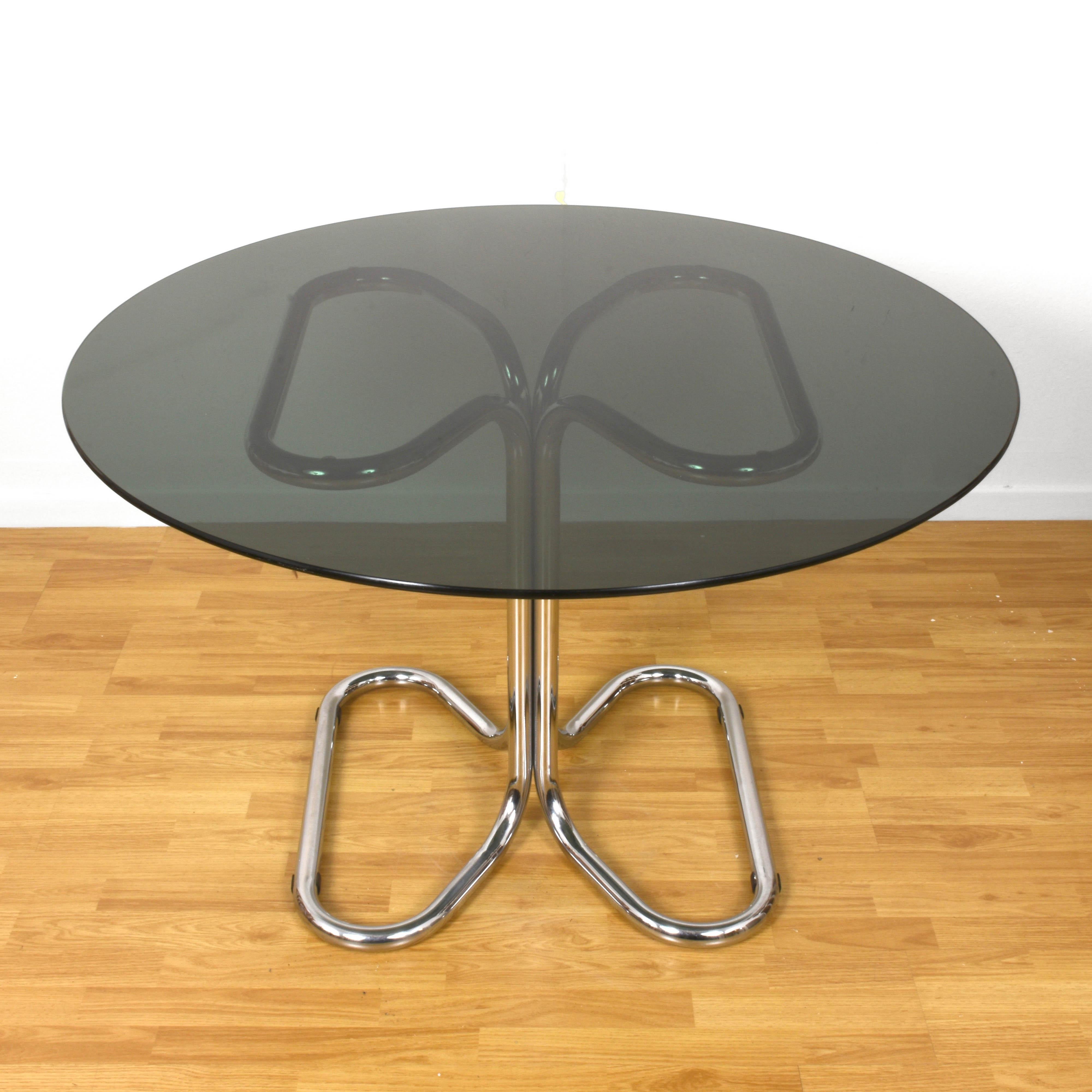 Italian dining table, Giotto Stoppino. Chromed metal base, smoked glass top. Measure: Diameter 118 cm.