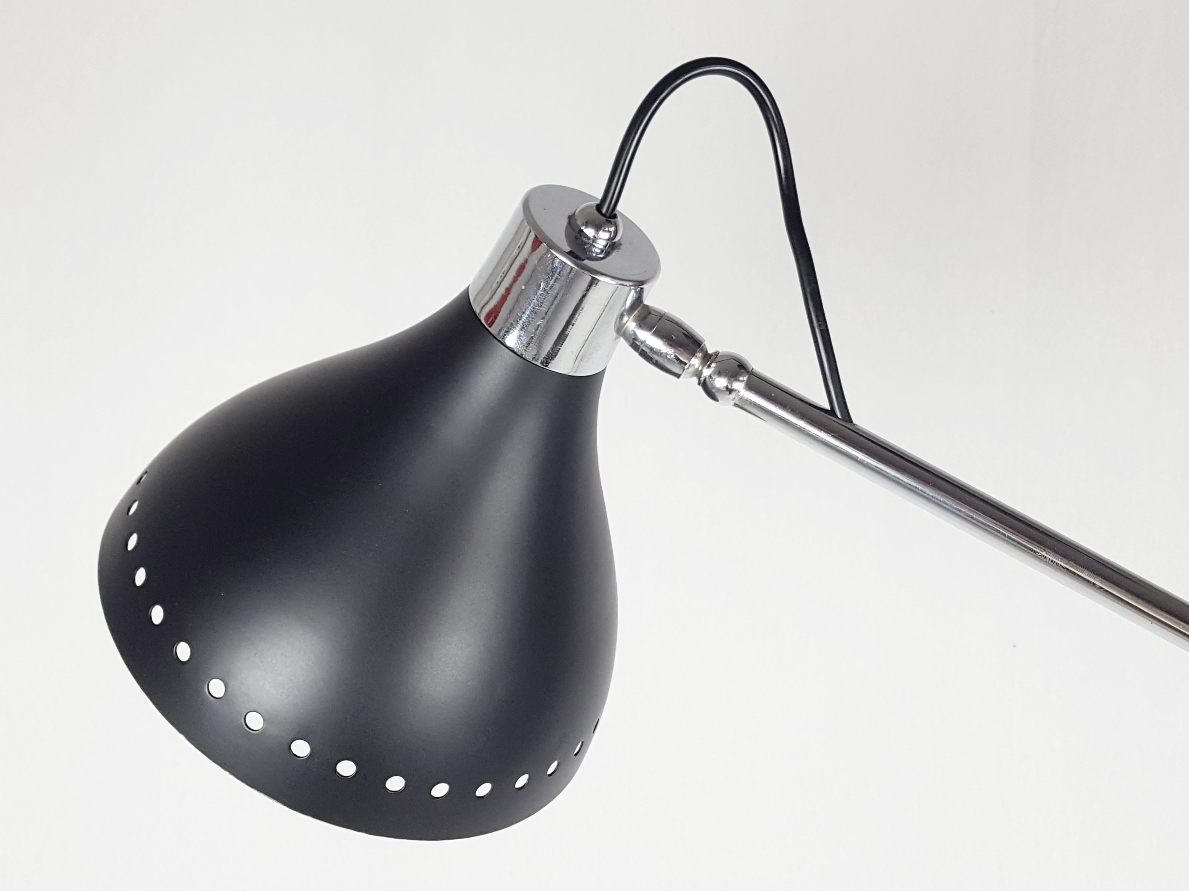 Adjustable floor lamp produced in the early '60s. Black painted metal rod & shades; chrome plated metal arms. Marble base.
Its design resembles the 