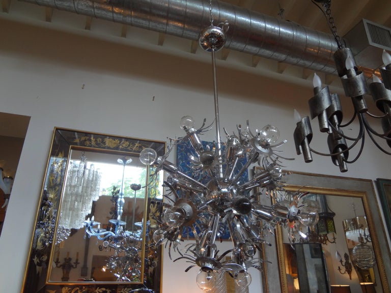 Italian Mid-Century Modern chrome Sputnik chandelier or pendant in the style of Gaetano Sciolari or Stilnovo, circa 1960. This unusual chandelier as alternating sockets and glass spheres. This fixture has been newly wired for the U.S. Market with