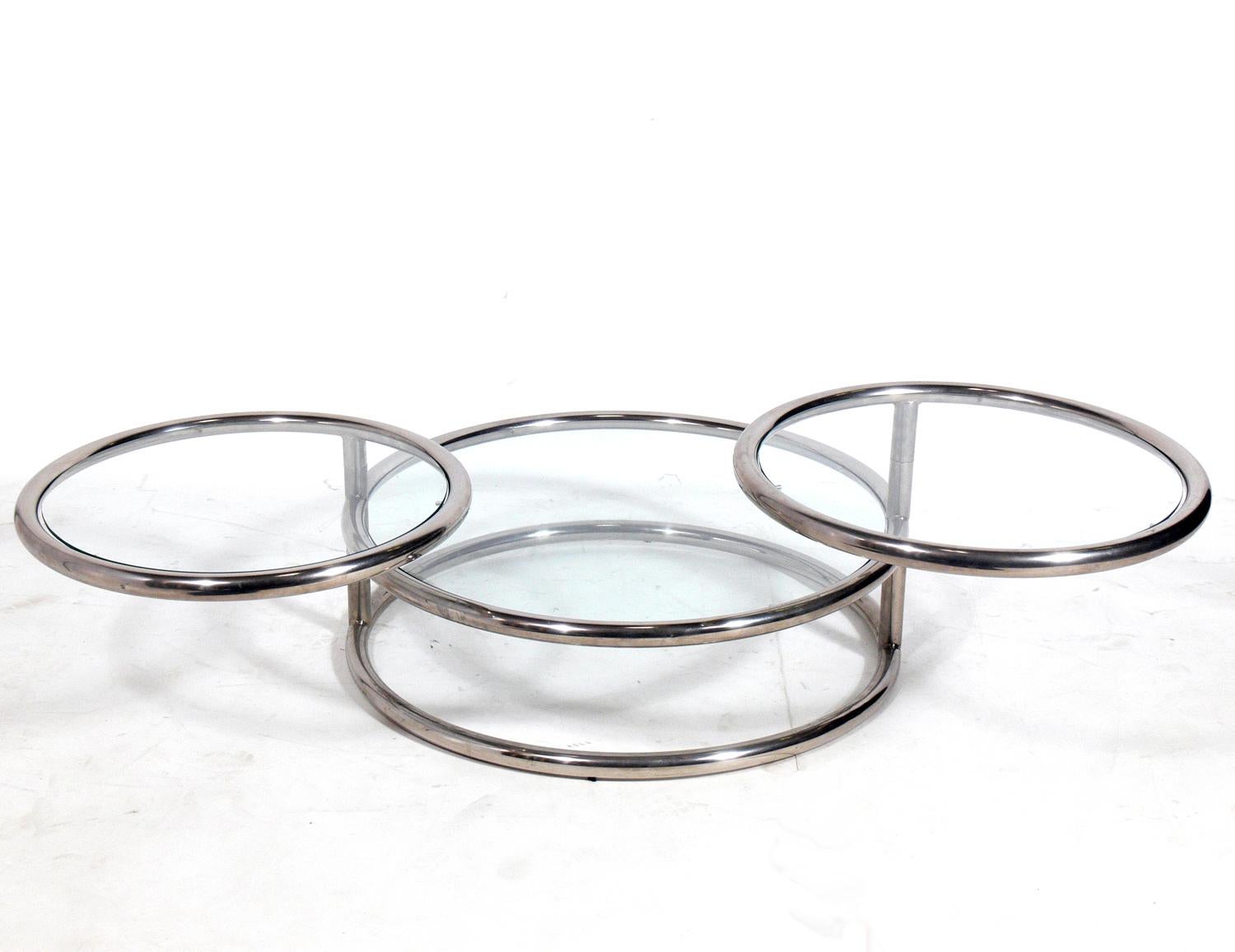 Chrome swivel coffee table, Italy, circa 1960s. Perfect for entertaining, as it has three glass tops, two of which swivel in and out.