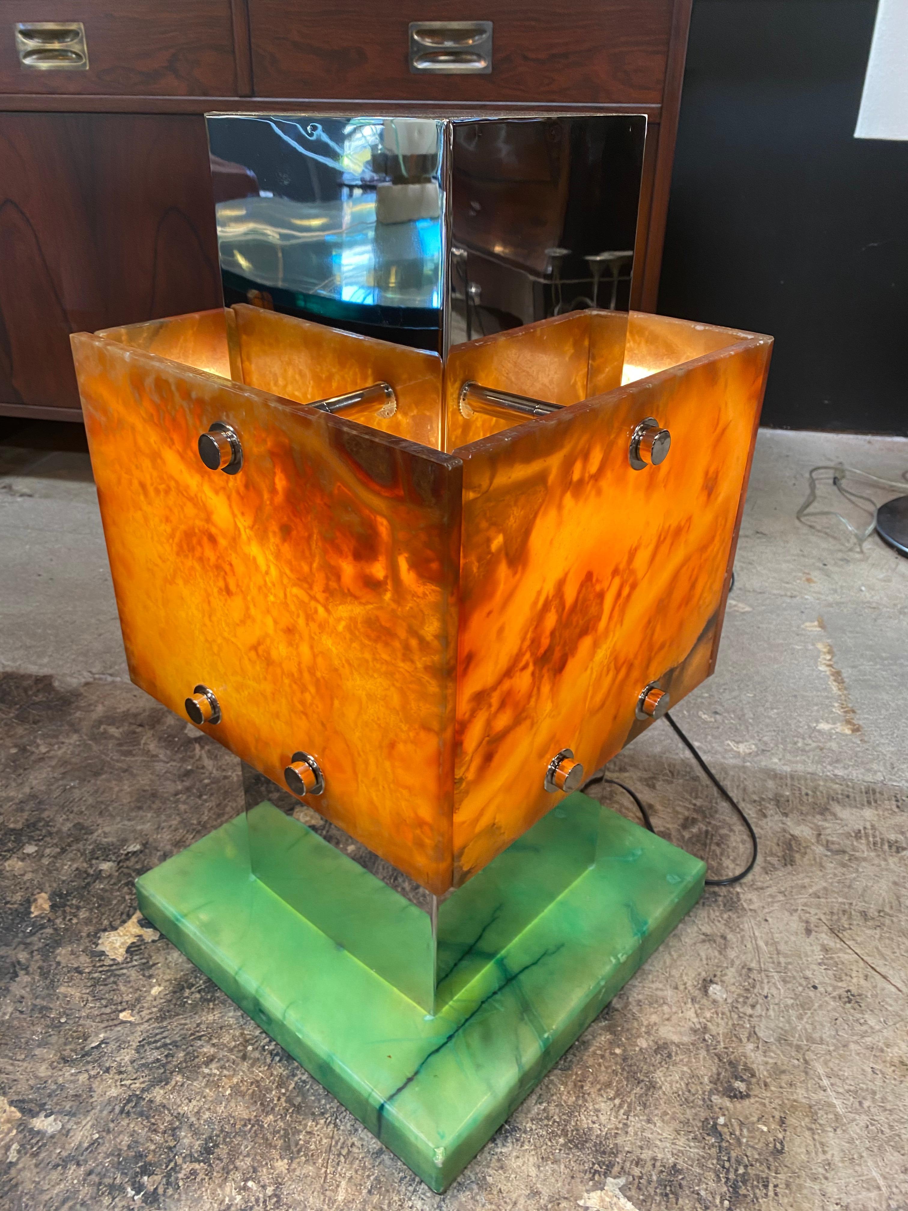 The body of this geometrical lamp is composed of two solids, one chrome and one (the shade) with an amber Lucite finish cut by hand.
The square Lucite base is 13 x 13.