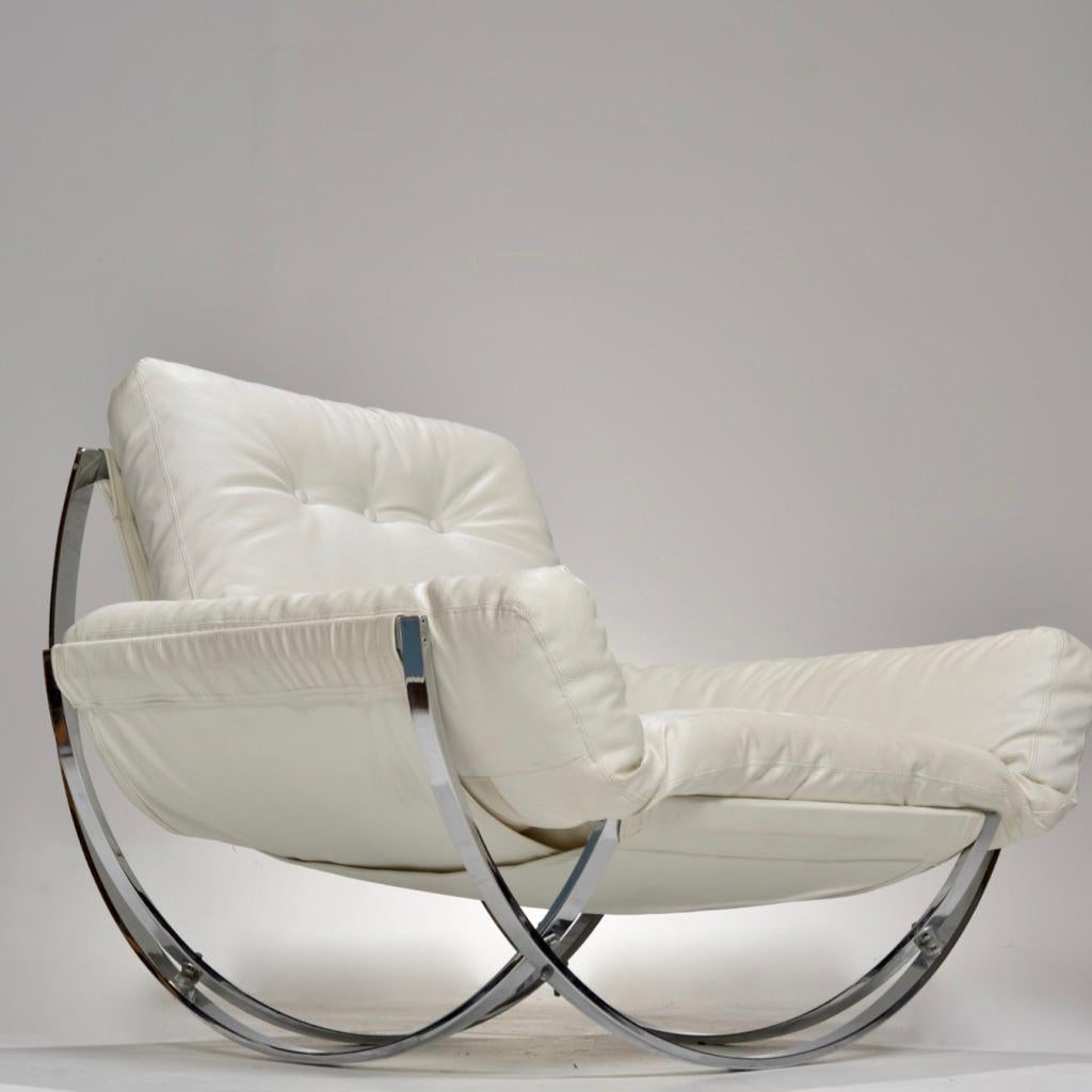 This lounge chair and ottoman by Stendig is quite the show stopper. 
It features overlapping curvilinear supports in chrome that attach to the base of each piece. It may look like a rocking chair but it is actually stationary. 
The ottoman and