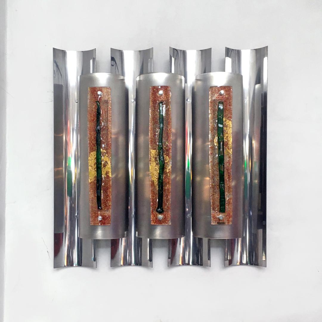 Italian chromed steel wall lamp with glass by Angelo Brotto for Esperia, 1970s
Wall lamp with chromed steel structure and colored glass decorations.
Produced by Angelo Brotto for Esperia, 1970s.

Good conditions.

Measurements: 67 x 13 x 71 H