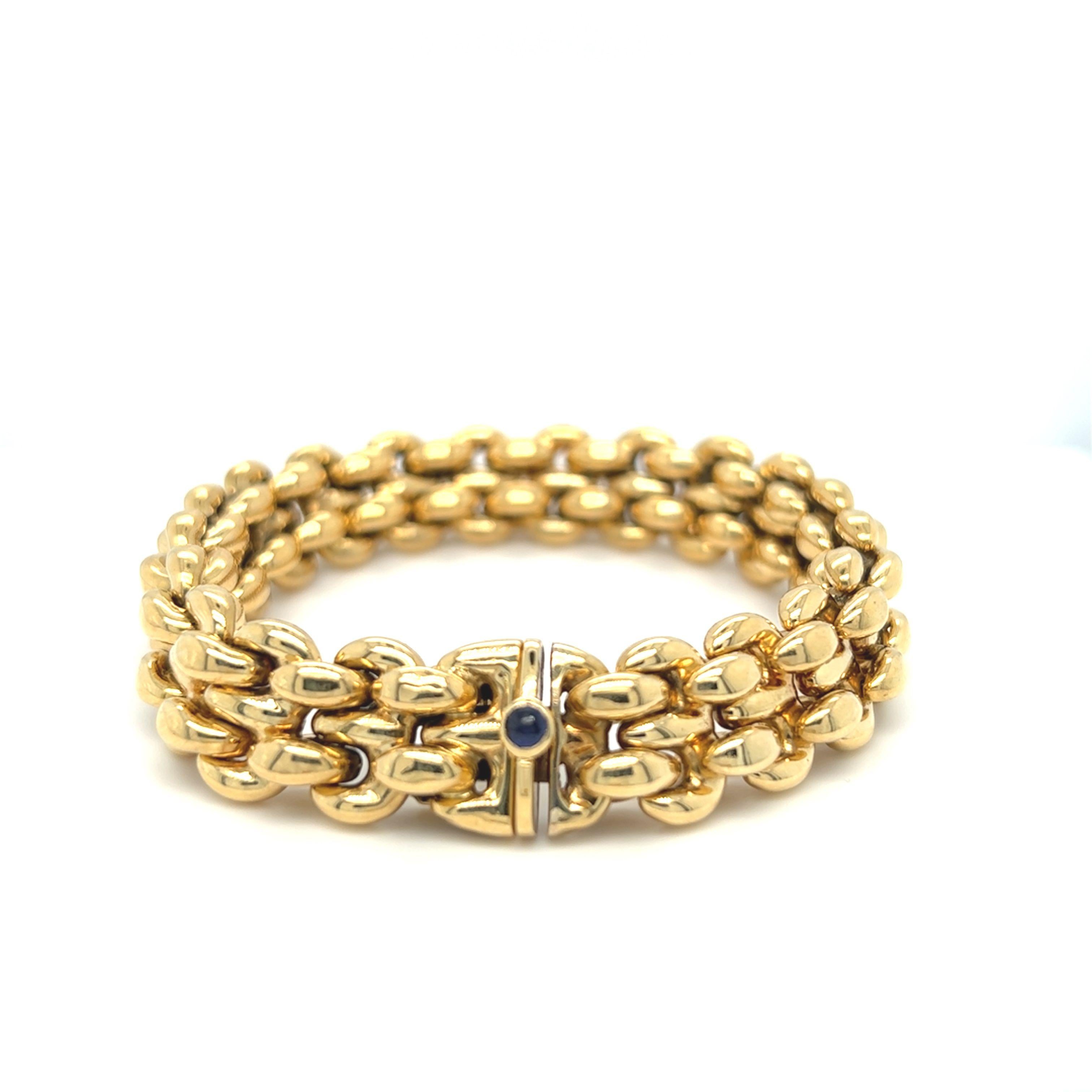 An Italian design with a contemporary feel, this 18K yellow gold bracelet has rounded double links alternating with connecting links. The clasp is decorated with a round cabochon cut sapphire with a deep navy blue color. The bracelet is 7 inches