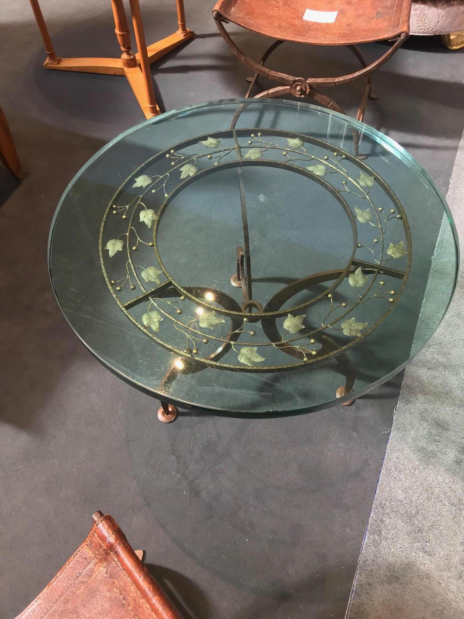 Circular wrought iron side table with scrolled leafs decoration fitted with glass.
Stamped at the base.
 



   
