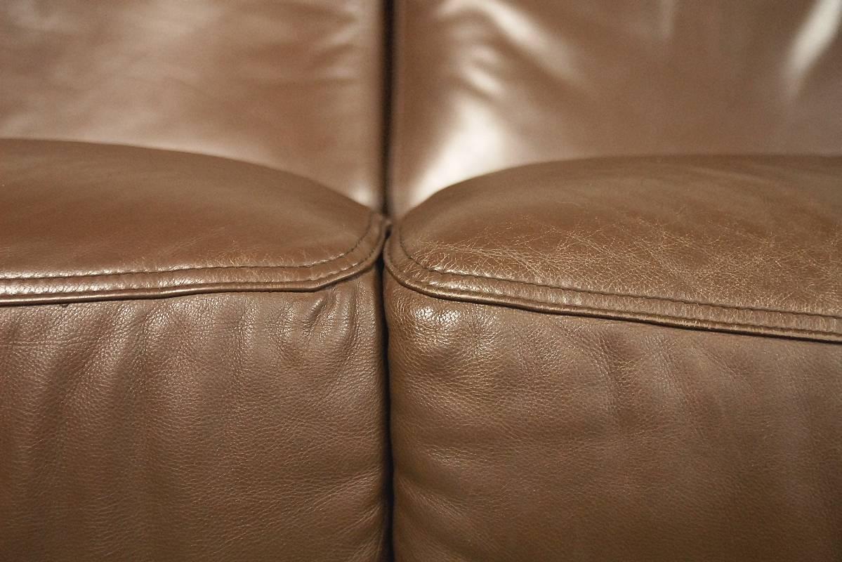 This two-seat sofa was manufactured in Italy by Brunati during the 1970s. It has a light and simple form and is very comfortable. This sofa is upholstered in patinated leather in a chocolate brown color. This sofa is in original vintage condition