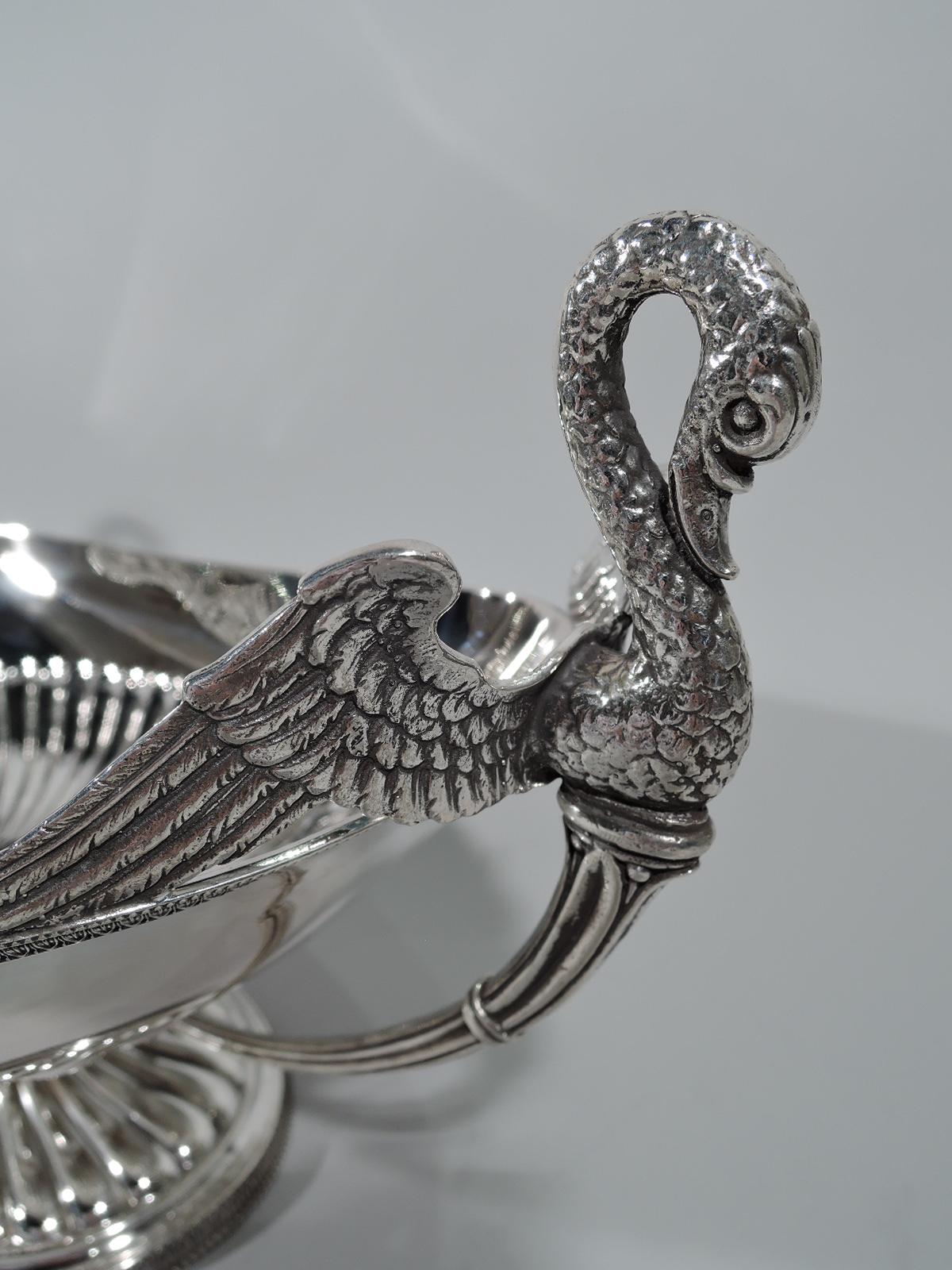 Classical Empire silver centerpiece bowl. Boat form with half gadrooning and tapering and reeded end handles with cast swan finials. Gadrooned and raised oval foot. Rims beaded with leaf-and-dart ornament. Italian hallmark (1944-68) for Ricci & C.