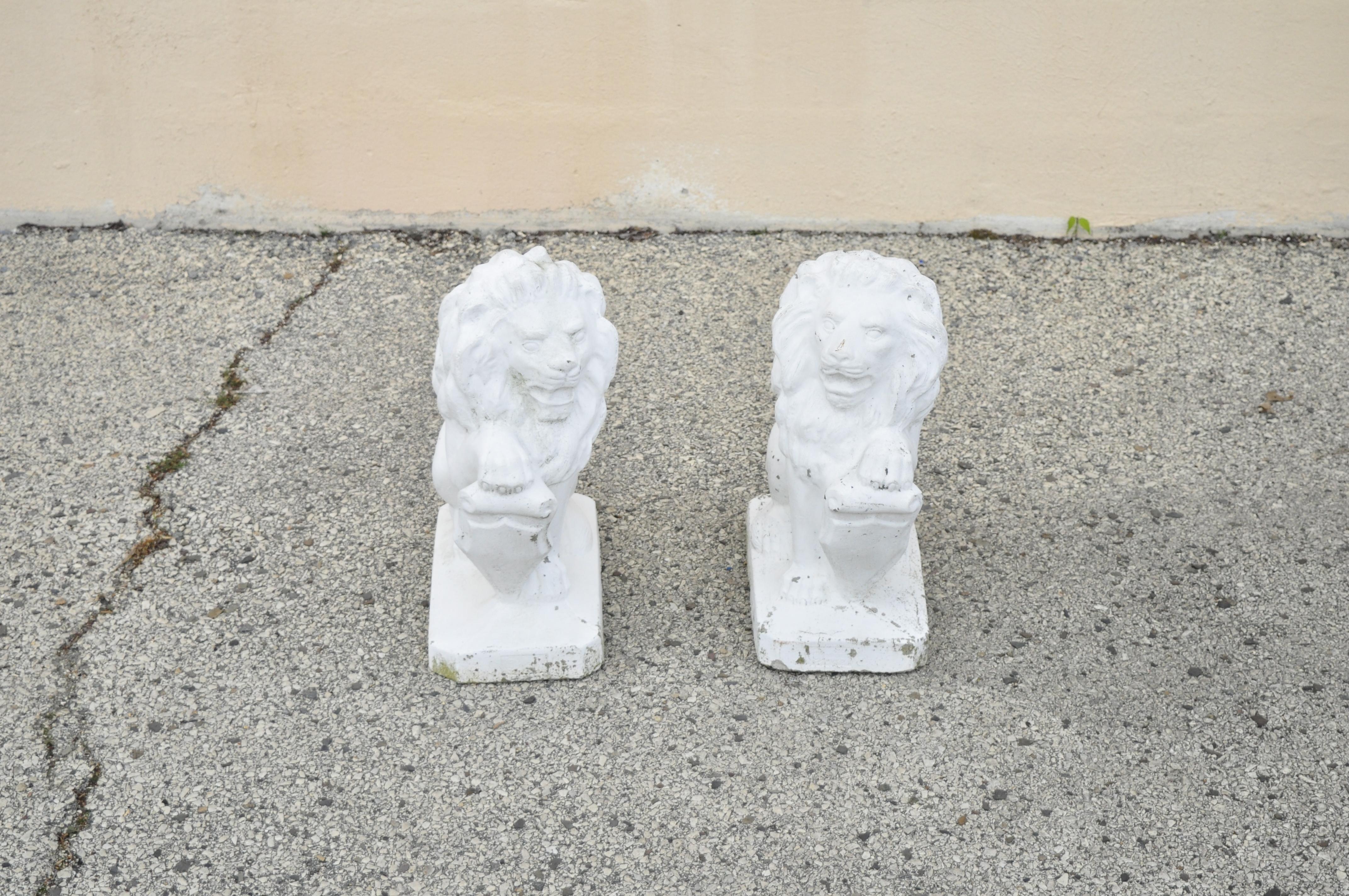 Vintage Italian Classical small lion and shield concrete lawn ornaments garden sculpture - a pair. Item features nice smaller size, lion forms with paw resting on shield, left and right facing, Circa mid 20th century. Measurements: 19