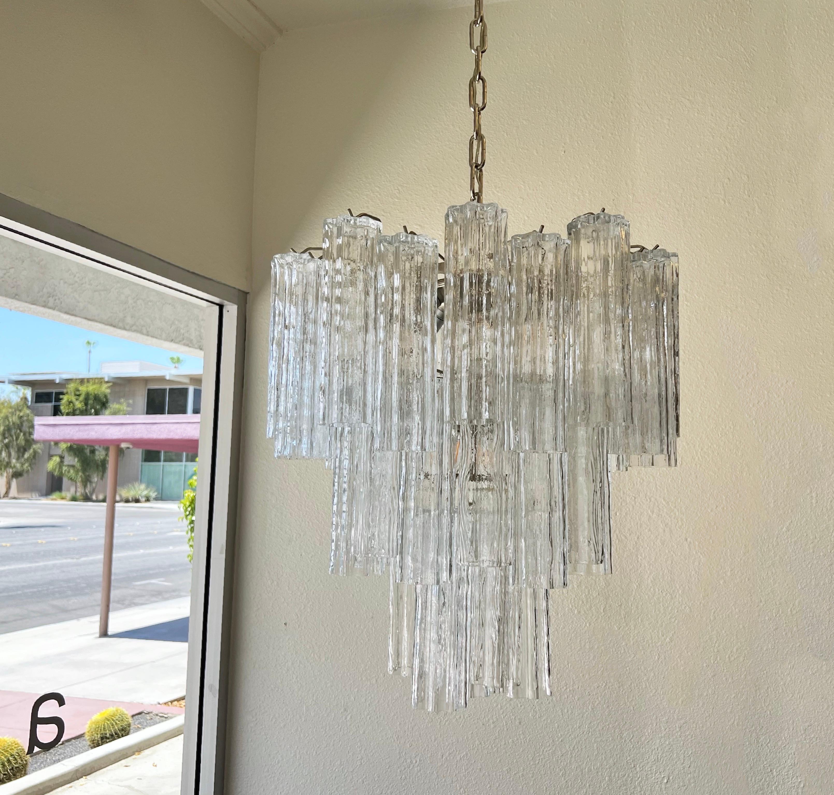 Glamorous 1970’s Italian clear Murano glass and chrome “Tronchi” chandelier. 
It has two different design of prisms that are the same length (See detail photos). 
New wire and chain. 
It takes 10 candelabra 40w Max lightbulbs. 

Measurements: 24”