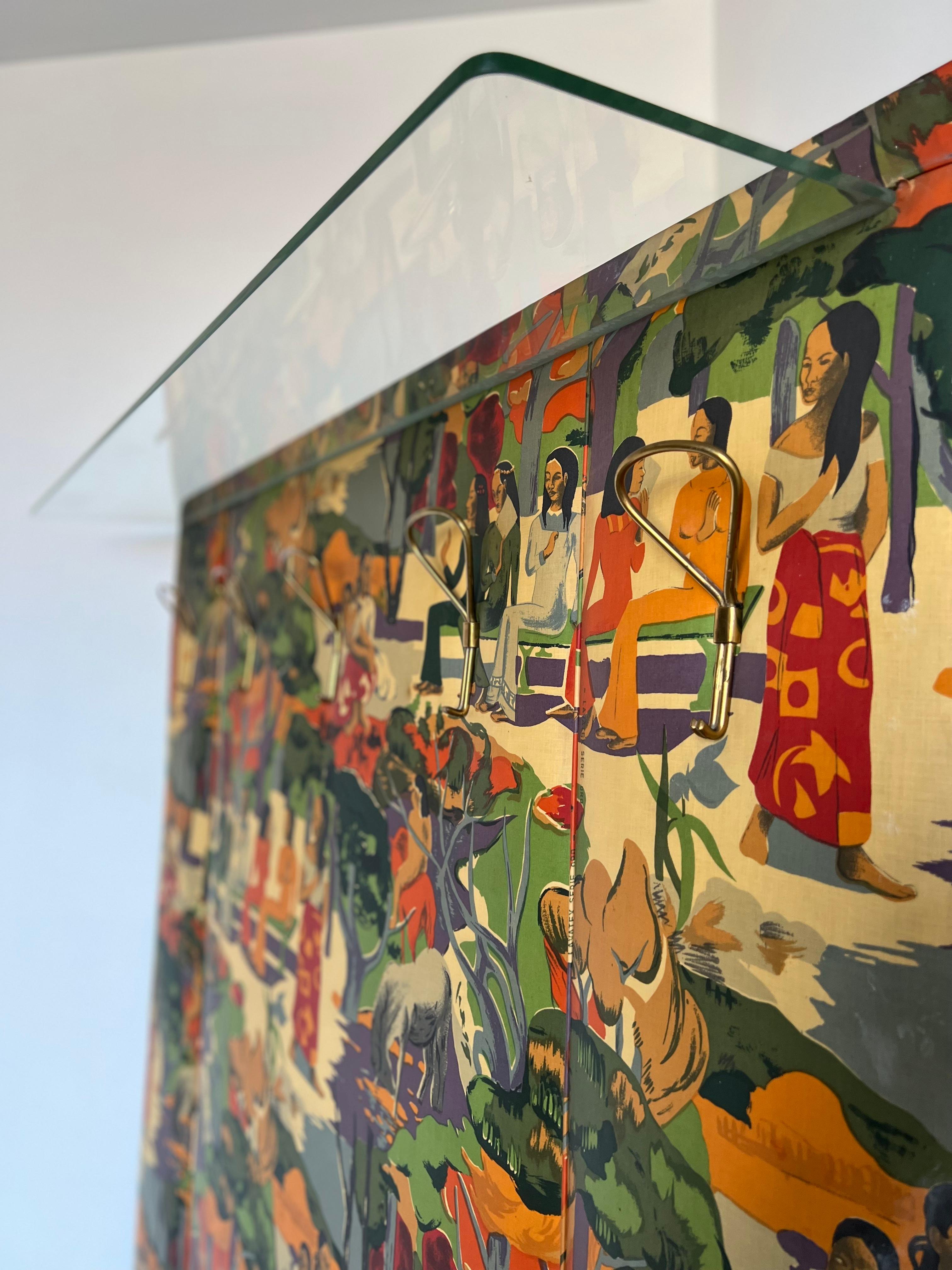 Eine unglaubliche italienische Wandgarderobe von Gino Geradini mit Glasablage und Messinghaken.
Ein Holzpaneel, bezogen mit Lavatex Serie Oro Stoff, inspiriert von dem berühmten Gemälde von Paul Gauguin 