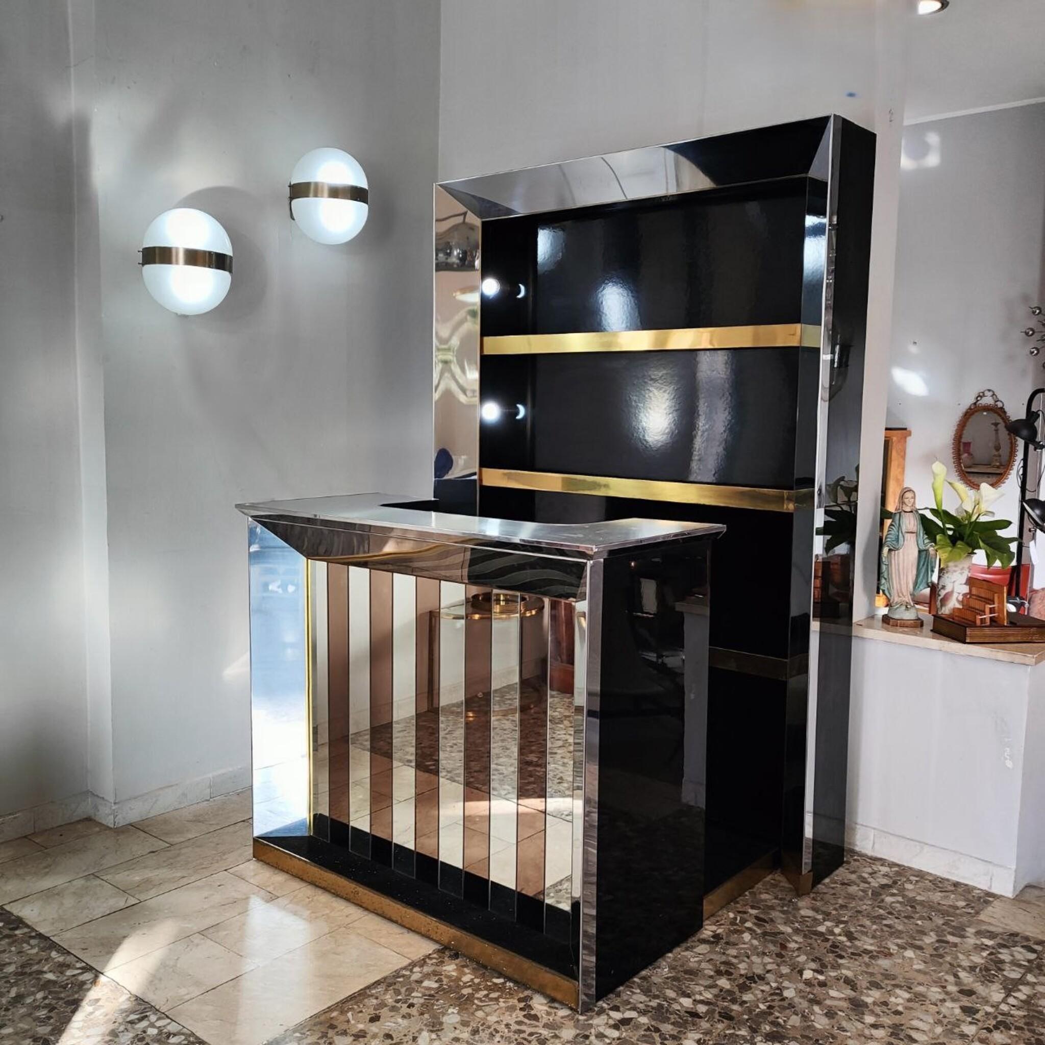 This stunning vintage bar cabinet is a striking representation of 1970s Italian design, channeling the luxurious and sophisticated style of Willy Rizzo.

The bar counter showcases bold bicolor glass panels, a brushed steel top, and lacquered wood,