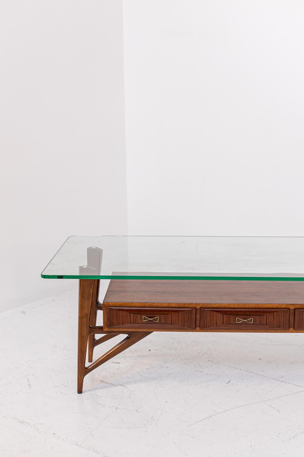 Large Italian coffee table attributed to Ico Parisi from the 1950s. The glass is original of the time and is very thick with beautiful green veining. Large size.
The coffee table has a nice line has 4 legs of triangular shape that act as a support