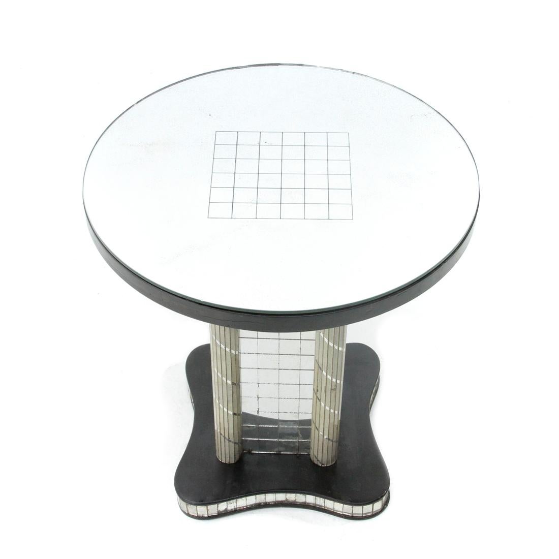 Italian-made coffee table produced in the 1930s.
Wooden structure.
Base with frame made up of tiles in mirrored glass.
Central column decorated with mirrors.
Top with mirrored glass decorated with a geometric motif.
Good general conditions,