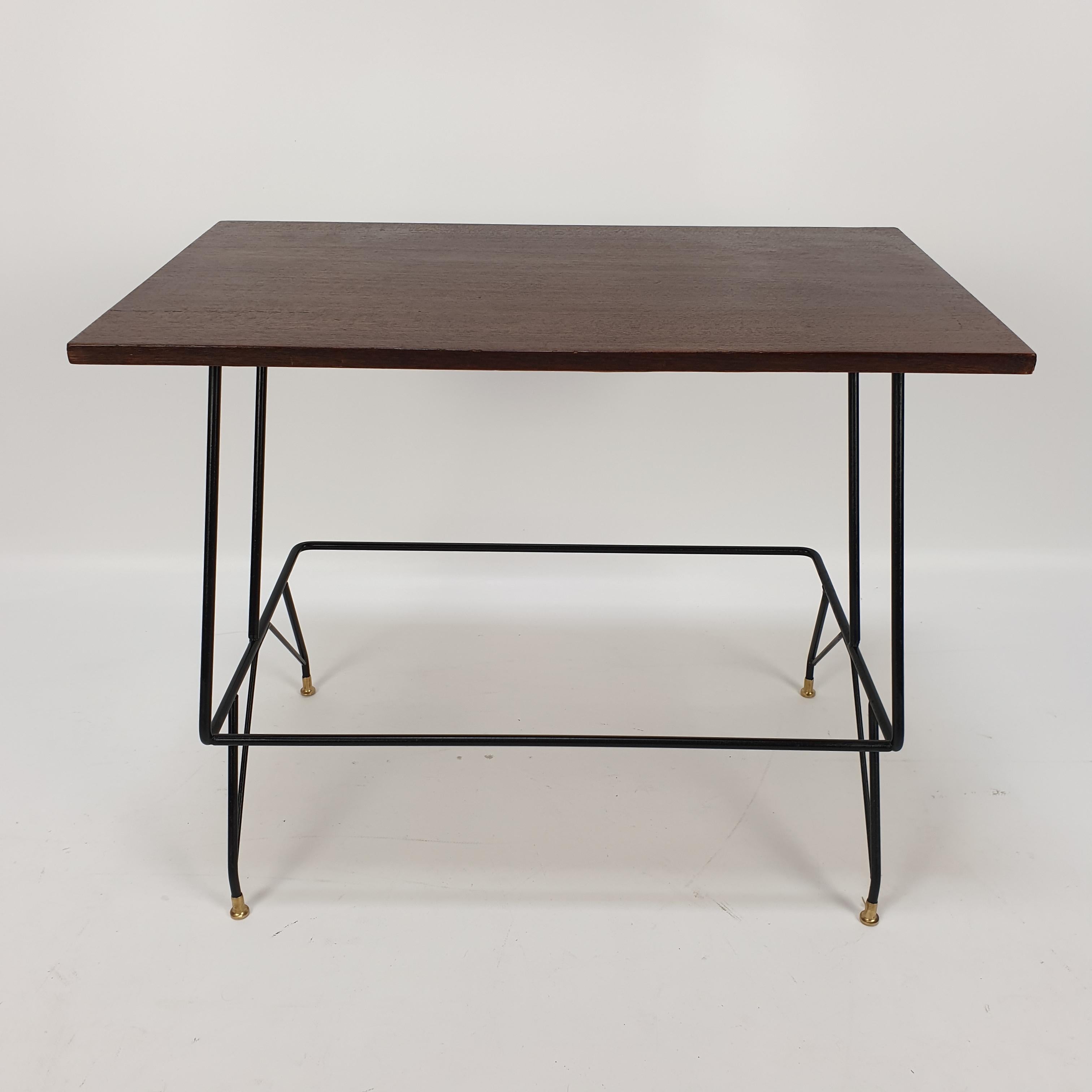 Raro tavolino da caffè Mobili Pizzetti Roma, prodotto in Italia negli anni '50. Forme eleganti in metallo nero e piedi in ottone. Piatto in legno di teak (impiallacciato).
 