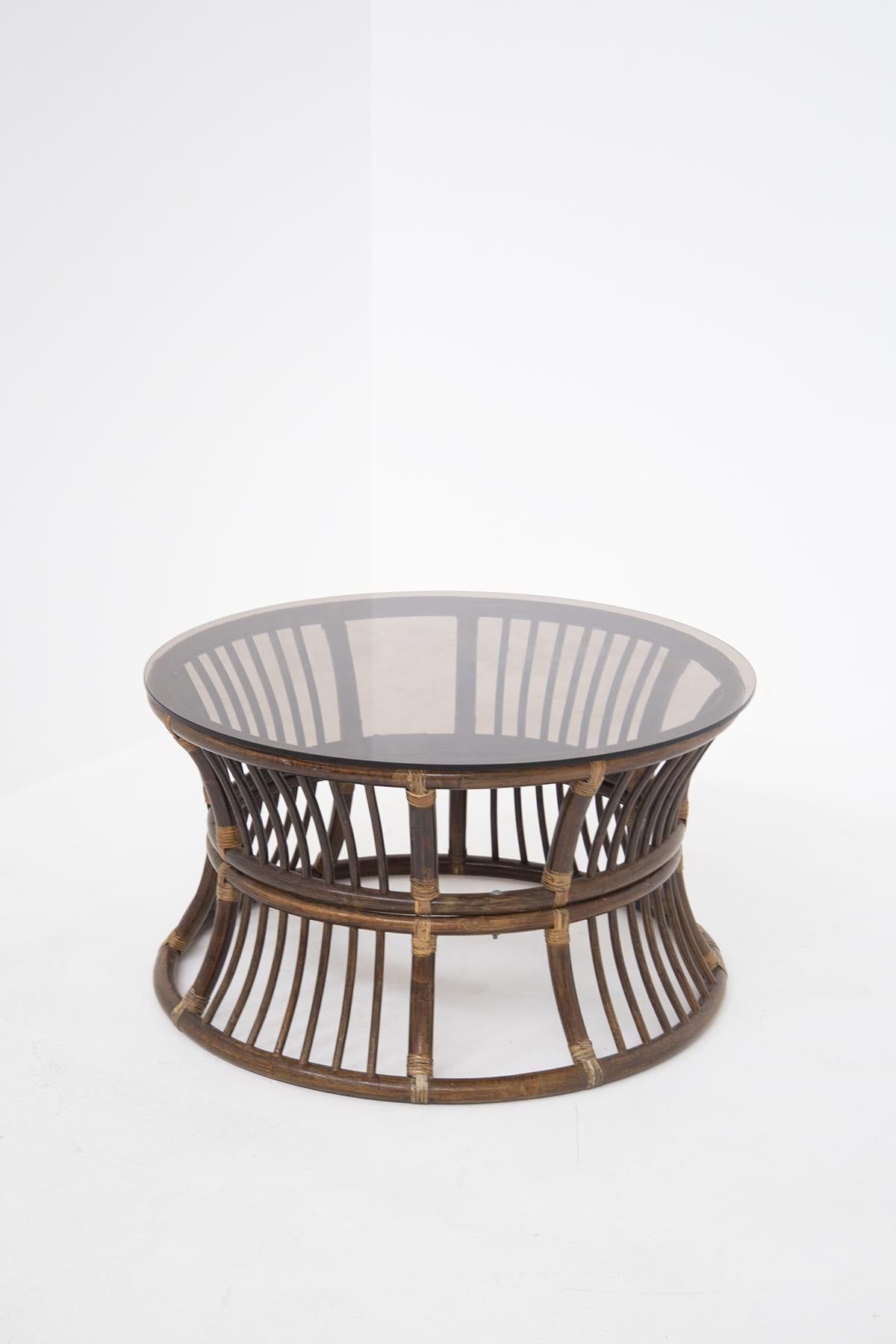 Italian bamboo coffee table with vintage glass top from the 1950s. The coffee table is made with a bamboo frame. Its table top is detached from its structure and is made of dark smoked glass with a circular shape. 
The coffee table is ideal for