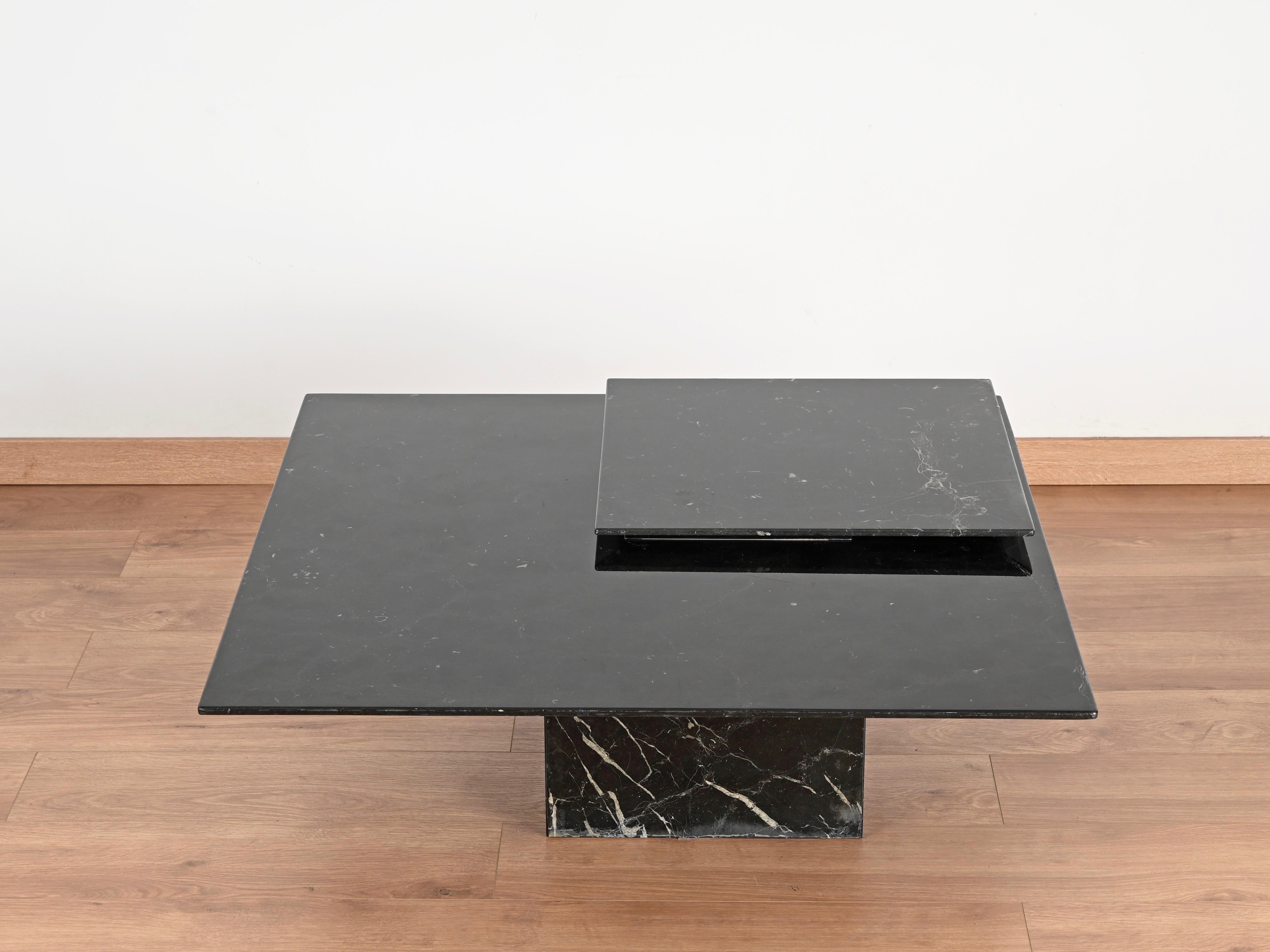 Fabuleuse table basse carrée entièrement réalisée en marquinha noir poli massif avec un plateau pivotant élégant. Cette table unique a été produite par Cattelan en Italie dans les années 1970. La table est signée sur le bord chromé.

En très bon