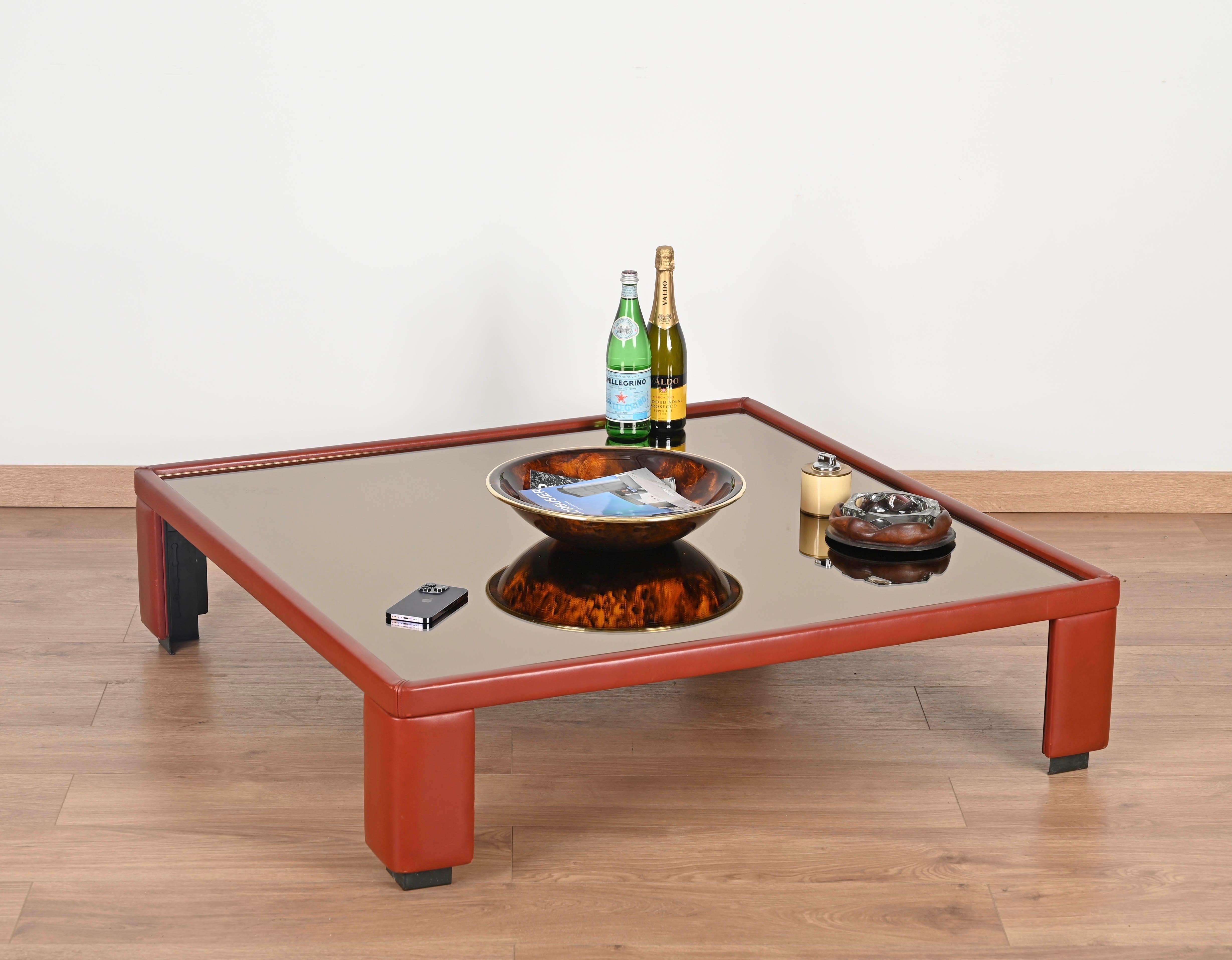 Atemberaubender niedriger, verstellbarer Couchtisch aus spektakulärem, kastanienbraunem italienischem Leder mit einer bronzenen, geräucherten Spiegelplatte. Dieser unglaublich stilvolle und einzigartige Tisch wurde von Luigi Massoni entworfen und