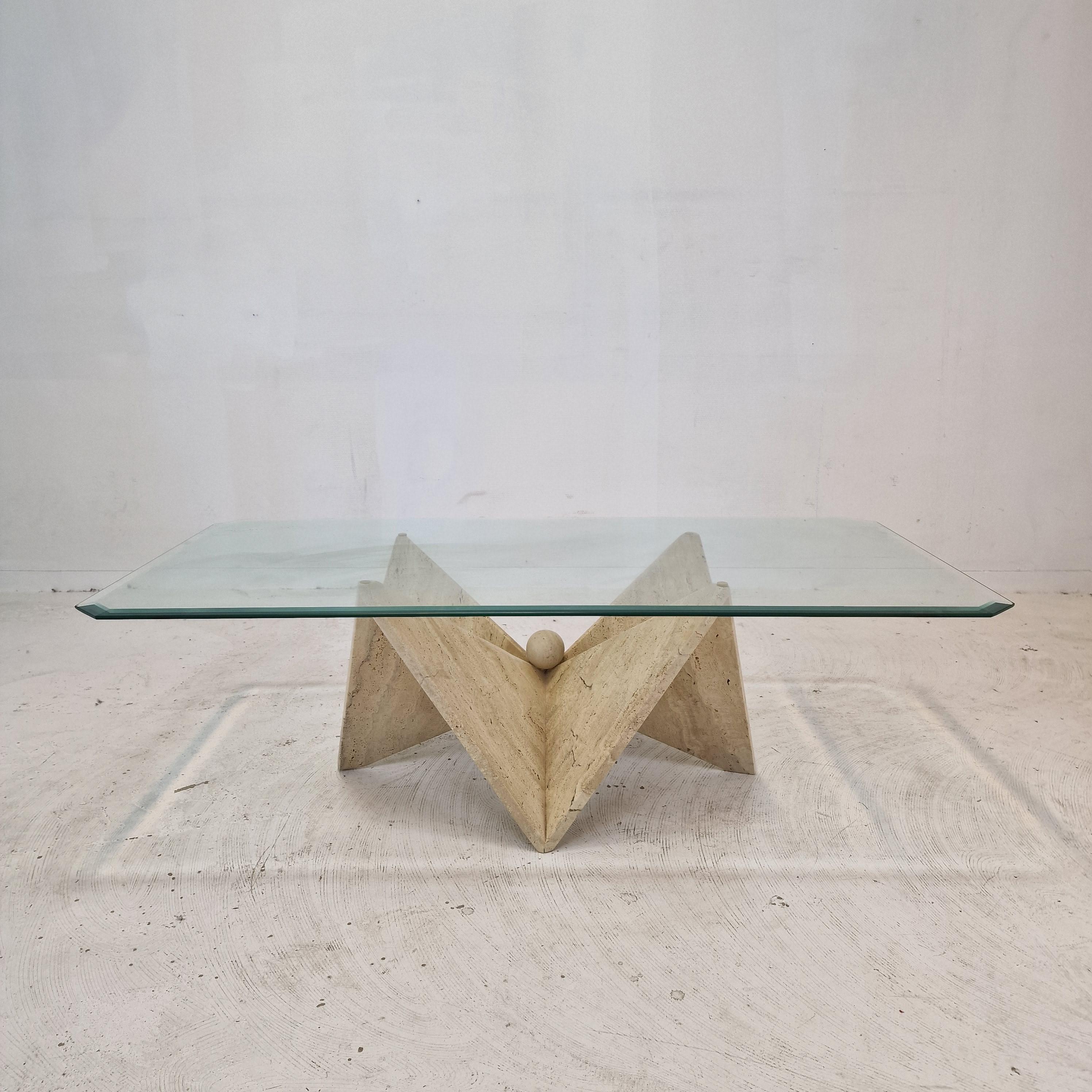 Stunning Italian coffee or side table handcrafted out of travertine, 1980s. 

The base looks like Origami.

It is made of beautiful travertine. 
Please take notice of the very nice patterns. 
The rectangle glass plate is facet cut.

It has the