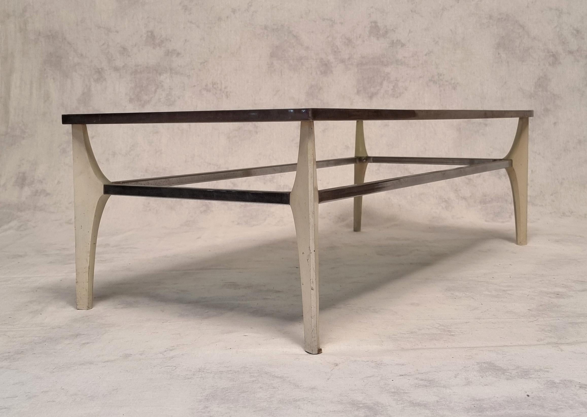 Vintage coffee table from Italy in the 1970s. Structure in chromed metal and top in smoked glass. The legs joined by chrome metal crosspieces are in white lacquered metal. She has great lines. In good condition, some wear. A slight thing to the