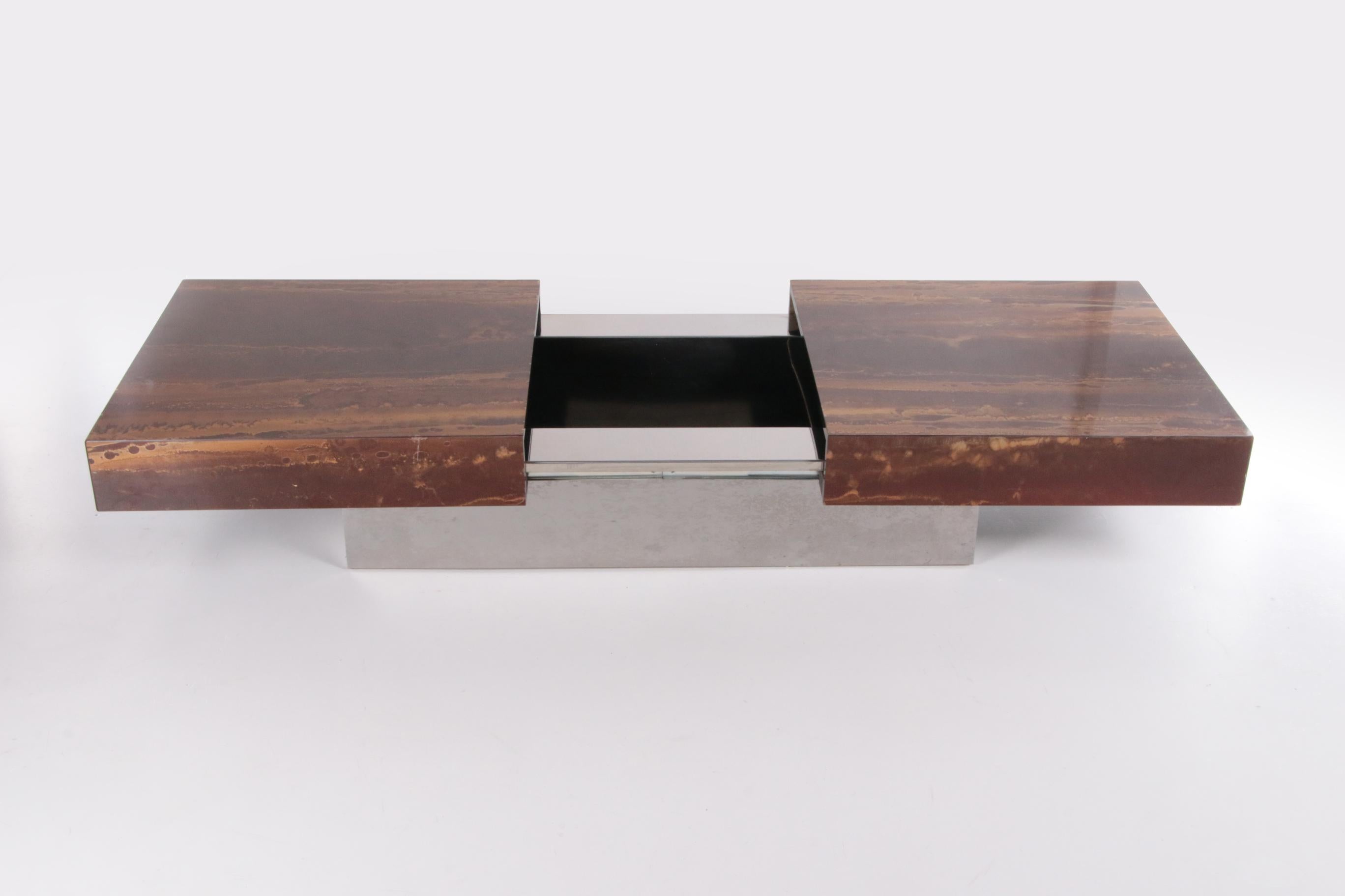 A beautiful coffee table designed by Aldo Tura in the 1970s. The table is made of wood with a beautiful pattern and finished with a high-gloss lacquer.

The tabletops on this table can slide to the left and right to reveal the bar inside. This space