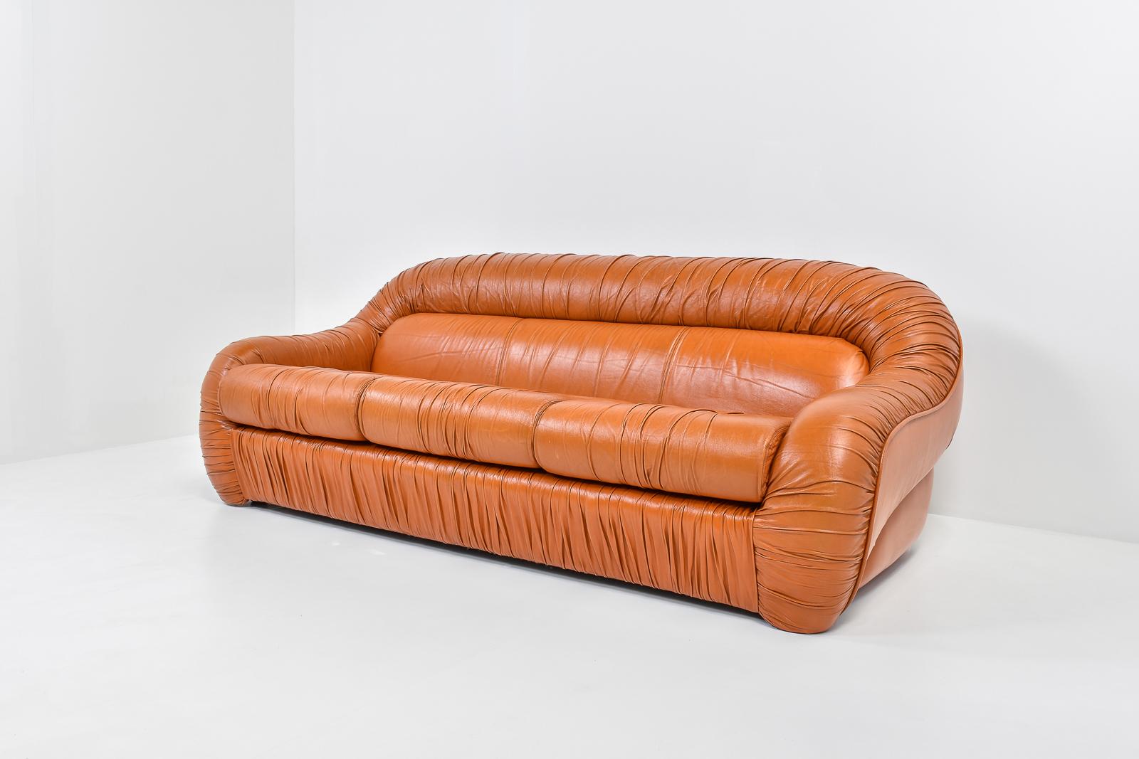 Very interesting 3-seater sofa in rich orange-cognac leather. The leather is in excellent condition and shows almost no traces of wear. The leather is ruched with a lot of detail. Very beautiful Italian space age sofa, which is exemplary for Italian