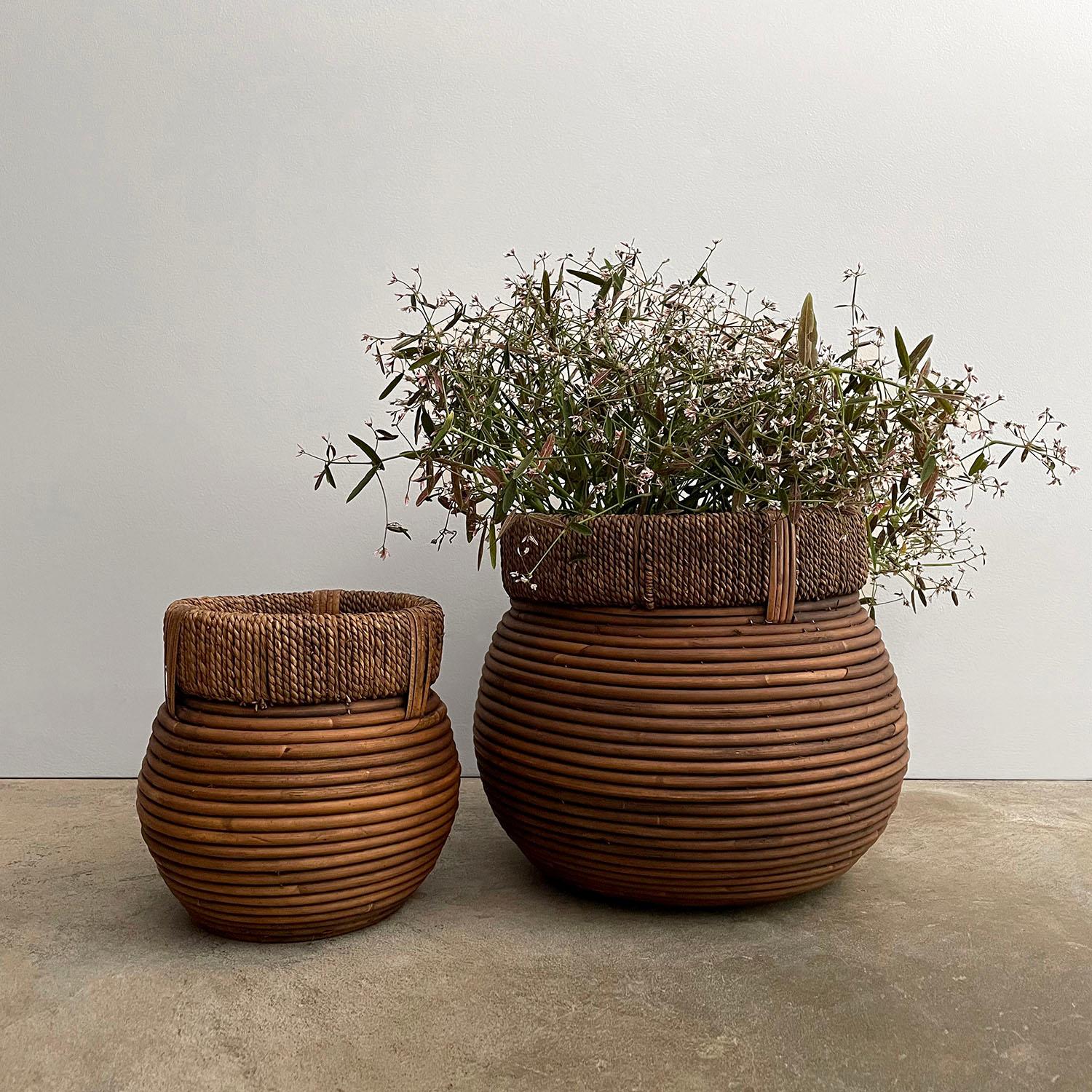 Italian coiled rattan bins
Woven rush seagrass banding 
Natural color variations throughout 
Patina from age and use 
Sold as a pair 

Small: 7.75” H x 8” Diam
Large: 10.25” H x 12” Diam
