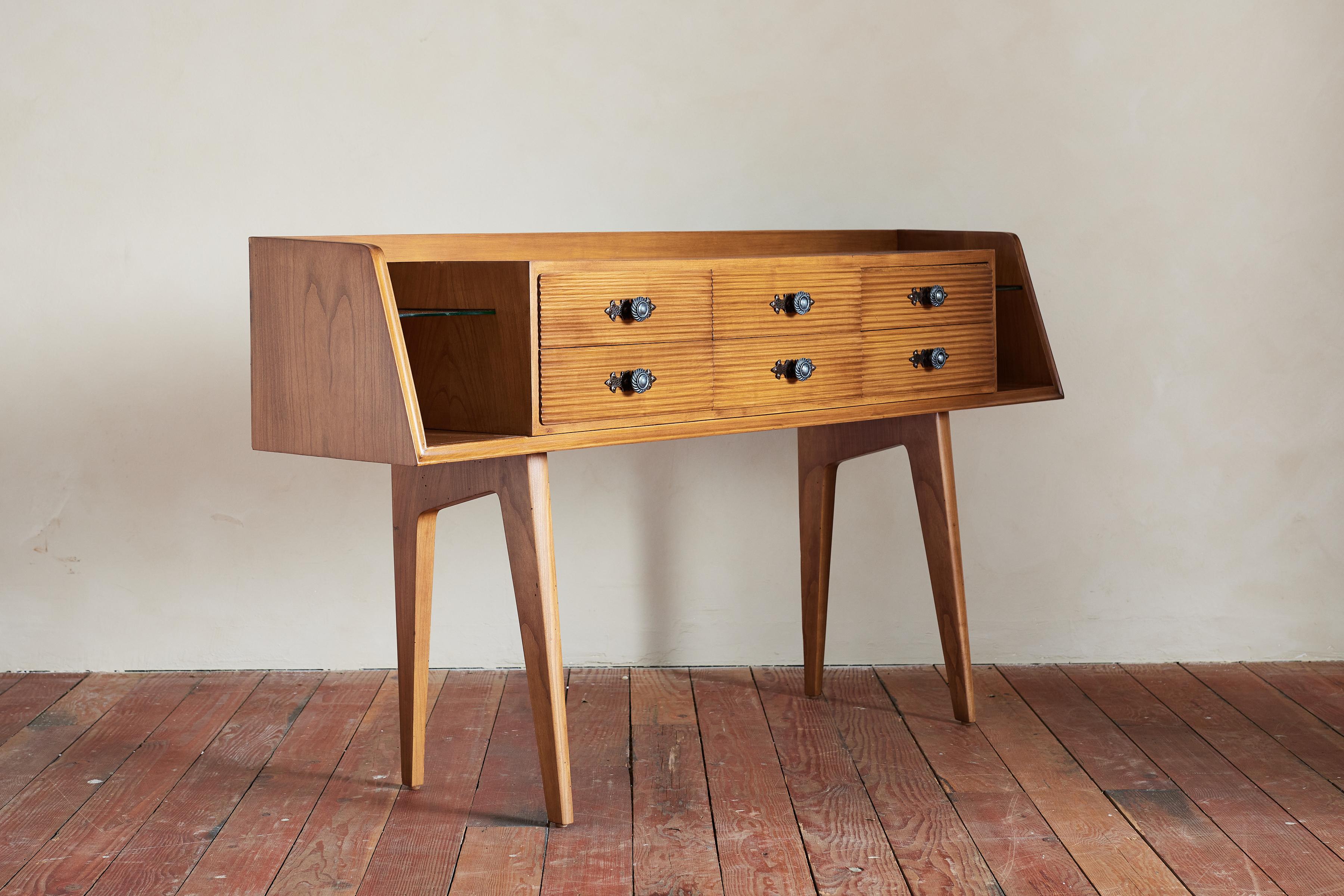Maravillosa consola italiana con cajones de madera peinada y herrajes decorativos. 

Patas angulosas que se estrechan 

Abierto por cada lado con estante de cristal flotante

Consola peinada. 

Italia, años 50.
