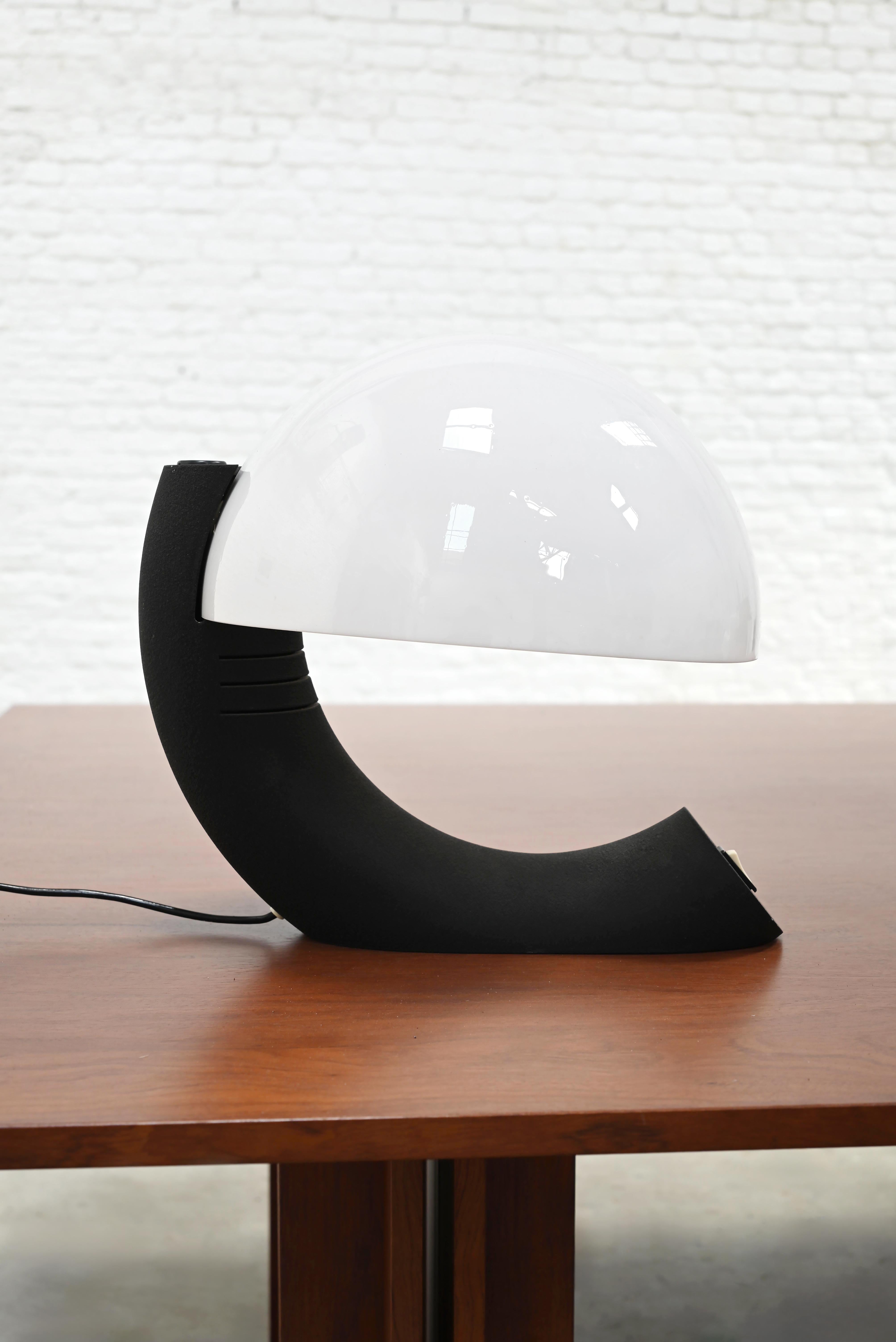 Designed by E. Bosi in the 1970s for Fratelli Martini, this Italian 'Concordia' table lamp reflects the sculptural language of the Space-Age era. A large circular plexiglass diffuser is supported by a sculptural textured metal base, creating a