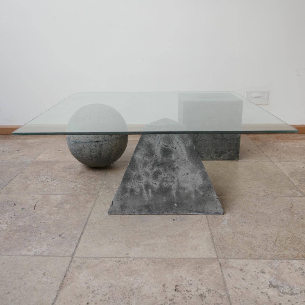 A mid to late 20th century coffee table in the style of Massimo and Lella Vignelli. 

Italy, c1980s. 

The geometric forms are made of a concrete or similar composite some have nicks and wear commensurate with age. 

The glass top has some