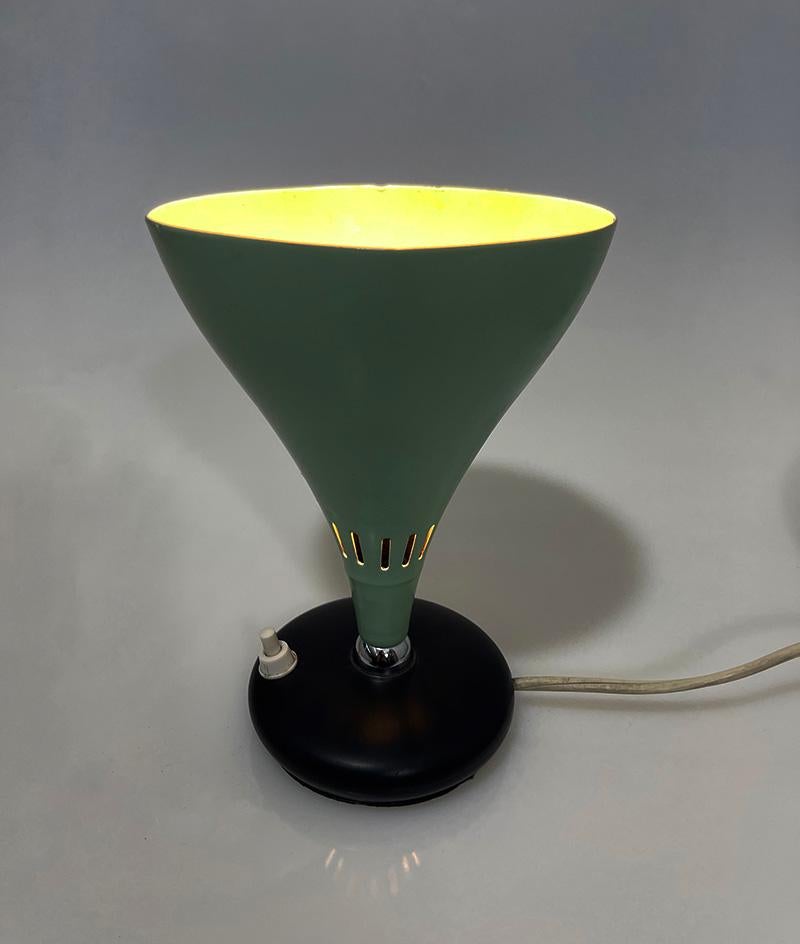 Italian cone uplighter lamp, 1950s

An Italian uplighter lamp with a conical lampshade perforated with vertical openings made of metal in the color mint green on a small round black metal base. The bottom is covered with a plastic lid and marked