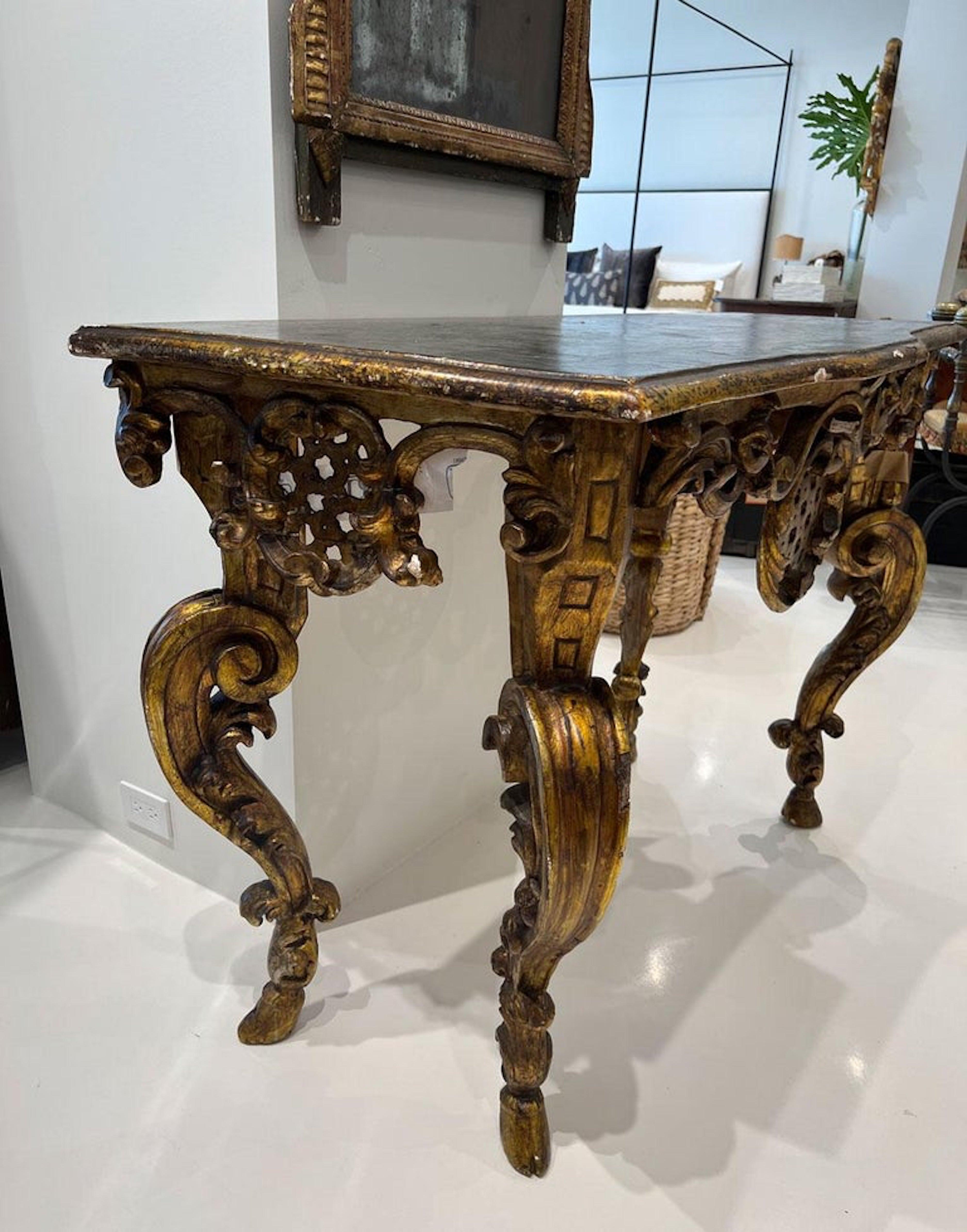 This amazing console table will not be ignored. All four legs are heavily carved with large cabriole legs tapering down to delicate hooves. The apron is festooned with swags and an unusual lattice medallion on three sides. All is topped off with a