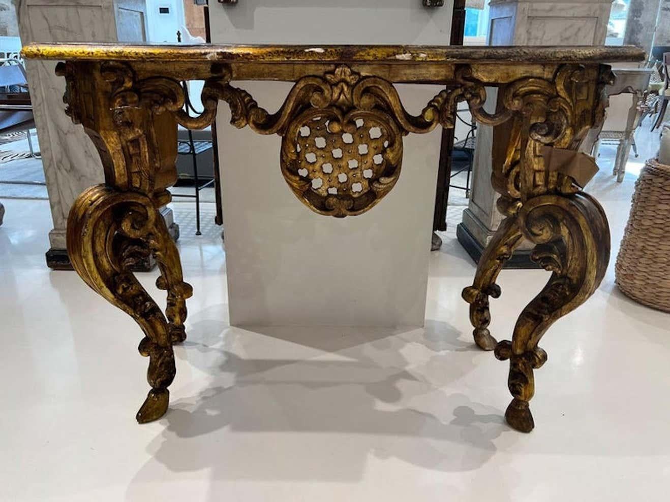 This amazing console table will not be ignored. All four legs are heavily carved with large cabriole legs tapering down to delicate hooves. The apron is festooned with swags and an unusual lattice medallion on three sides. All is topped off with a