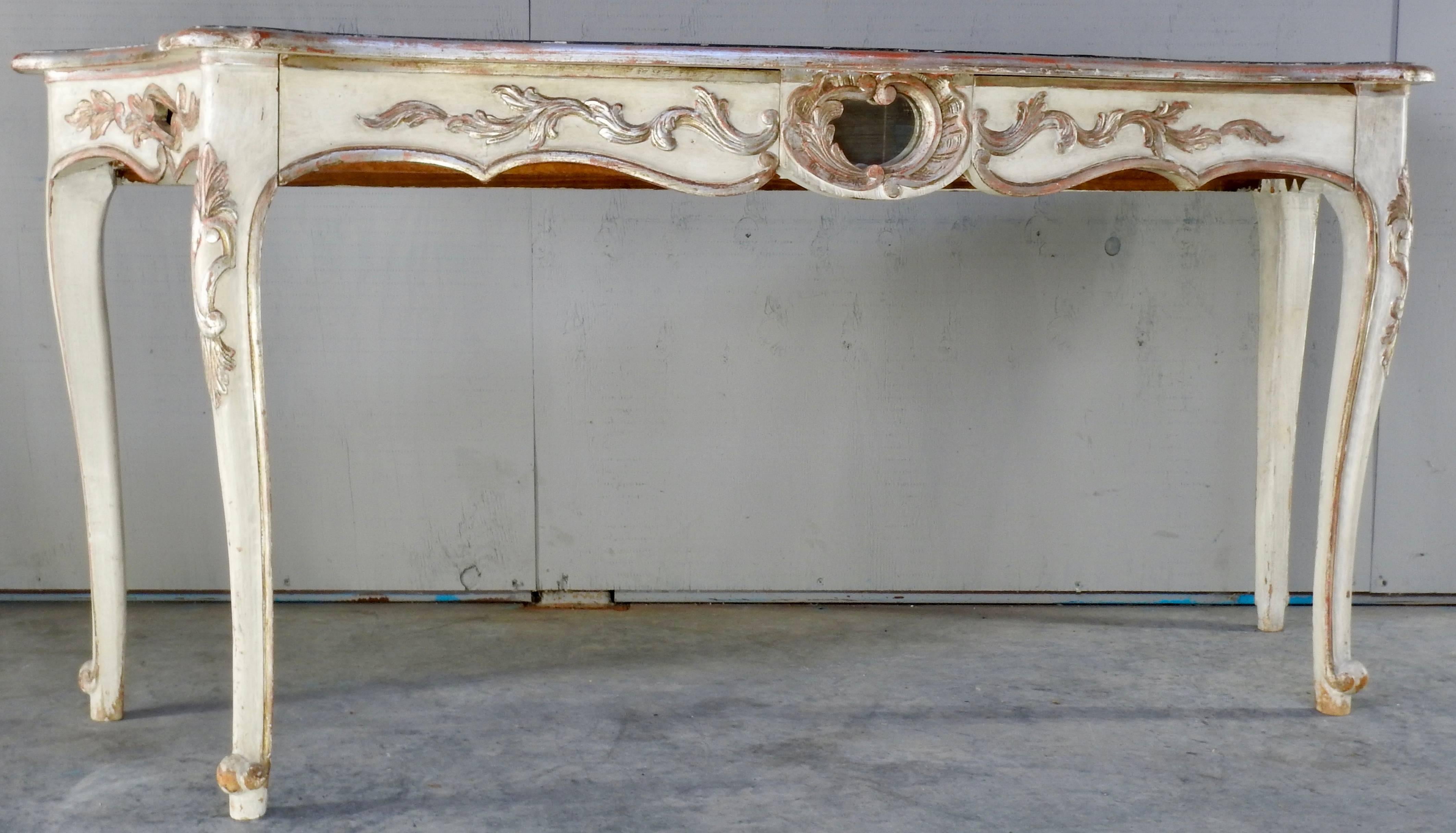 Offering this beautiful hand painted Italian console table with the base of white and silver gilt detail. The top has a trim that is a beautiful deep green. There are three cut-outs, two on the ends and one in the centre that are backed with mirror.