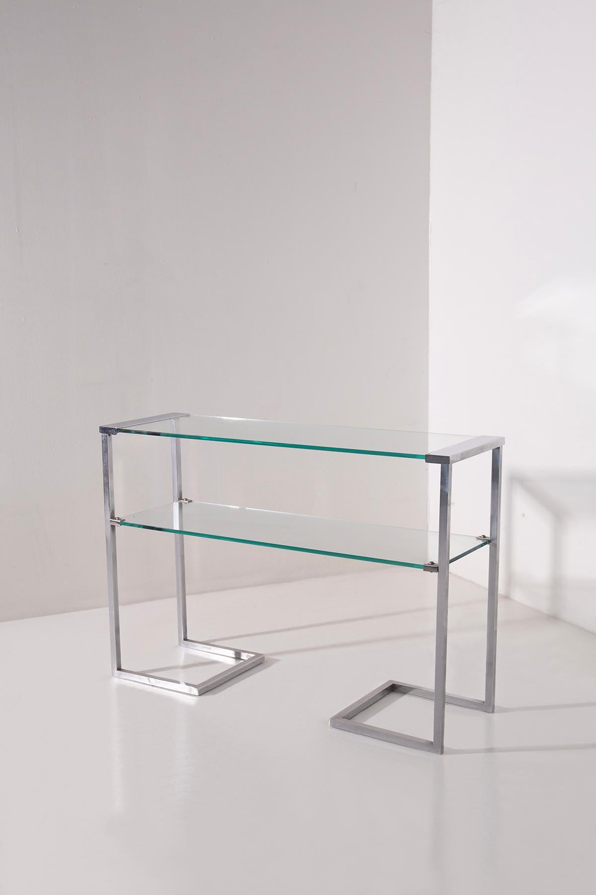 Ejemplo icónico del diseño italiano de los años 70, esta mesa revistero o consola de dos niveles combina funcionalidad, ligereza y elegantes proporciones en una forma minimalista pero sofisticada.

La estructura está fabricada en metal cromado de